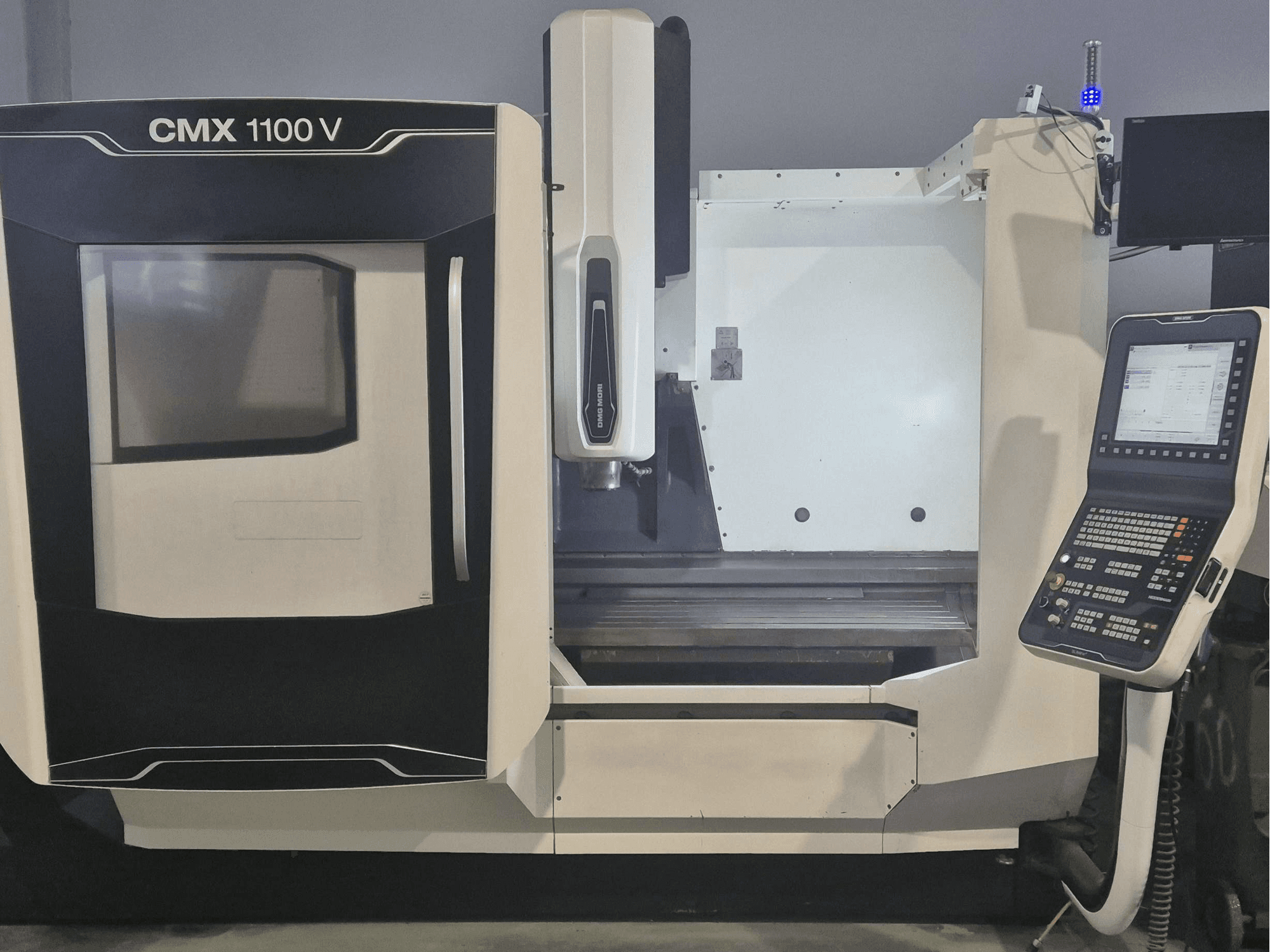 Vertikales Bearbeitungszentrum DMG MORI CMX 1100 V, Vorderansicht mit Bedienfeld und Maschinenbett.