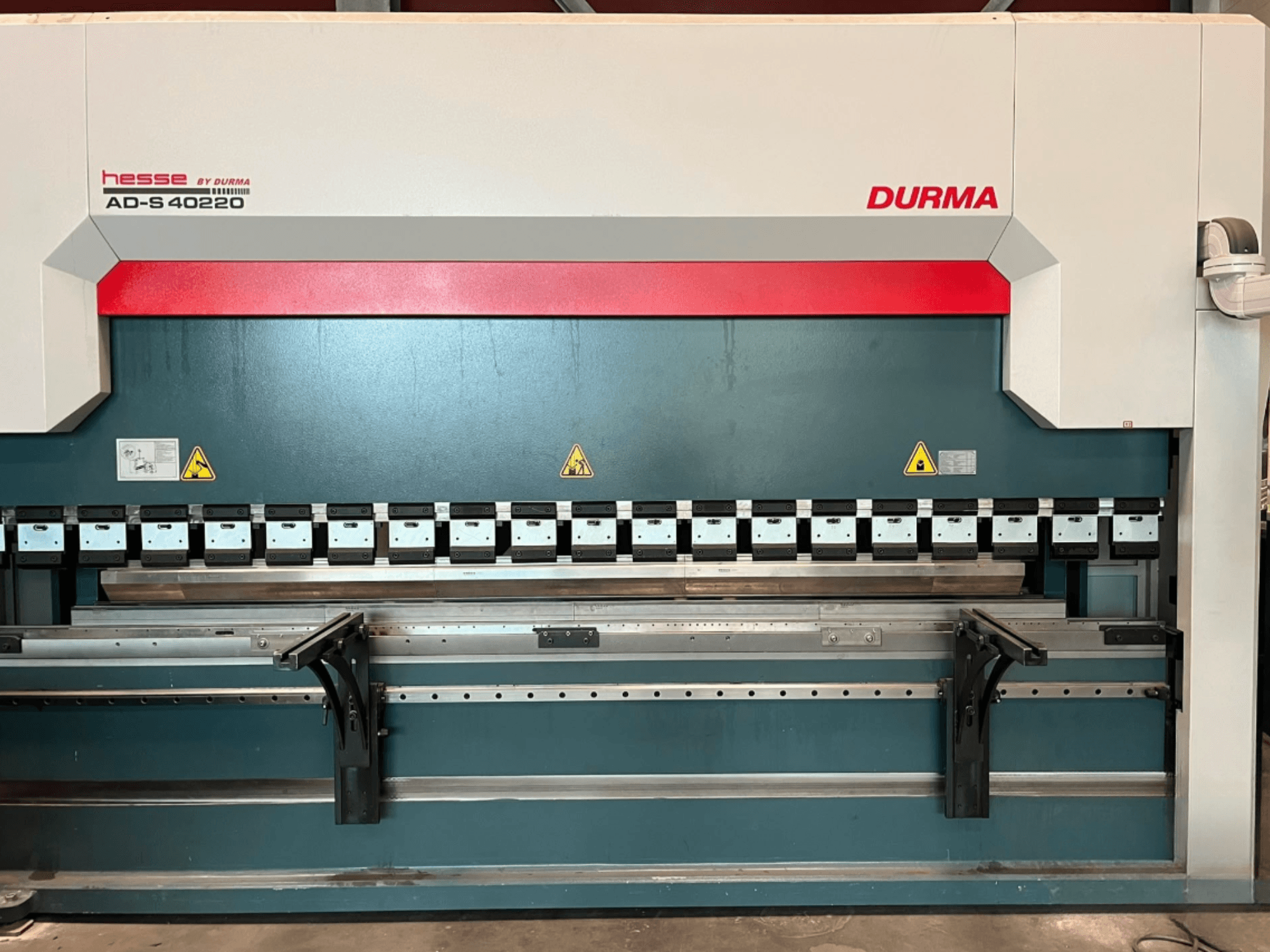Durma AD-S 40220 Abkantpresse in Frontansicht, mit verschiedenen Biegewerkzeugen und Sicherheitsaufklebern.