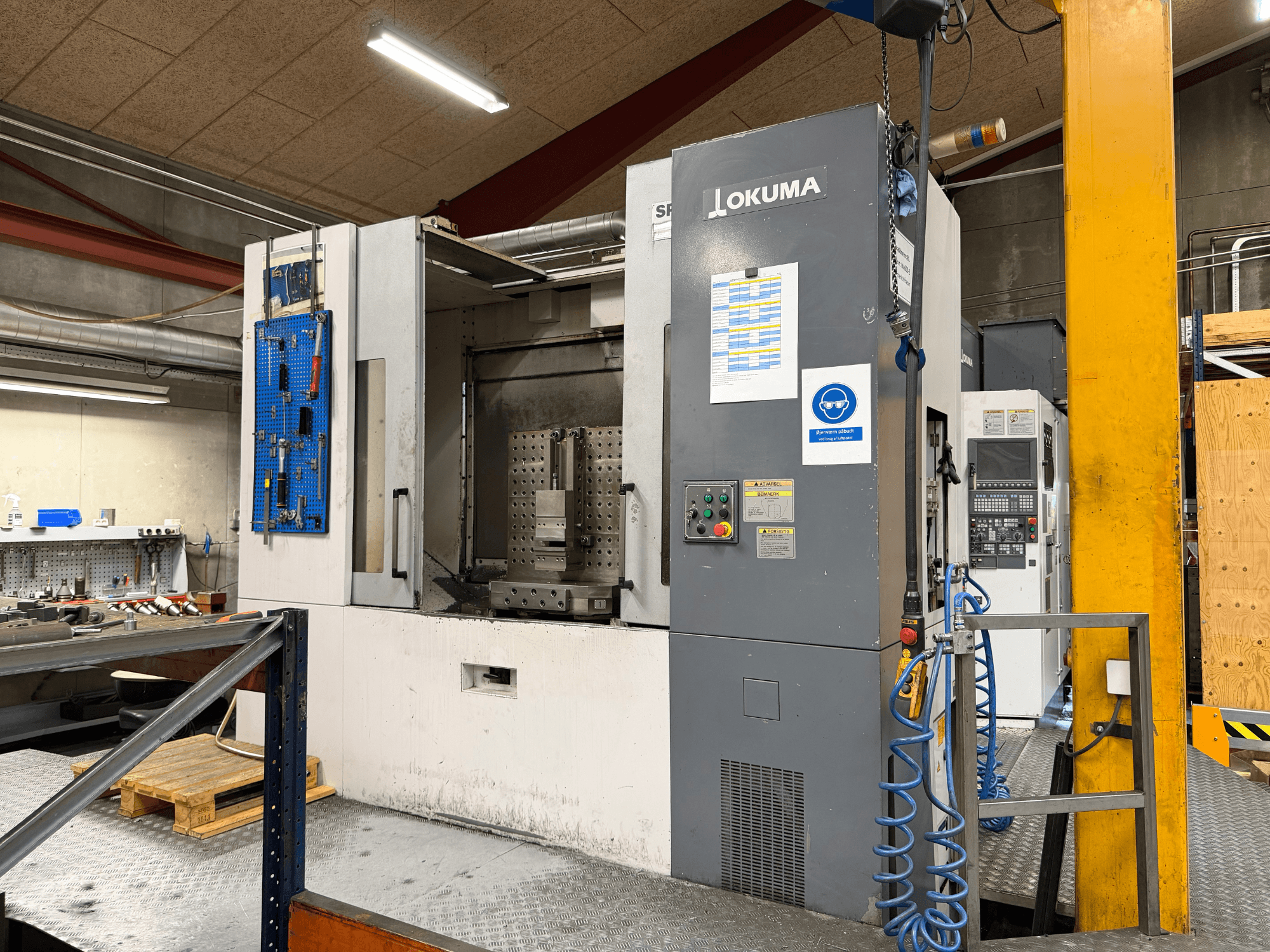 Horizontales Bearbeitungszentrum Okuma MA-600HB in einer Werkstatt, Vorderansicht mit Bedienfeld und Arbeitsbereich.