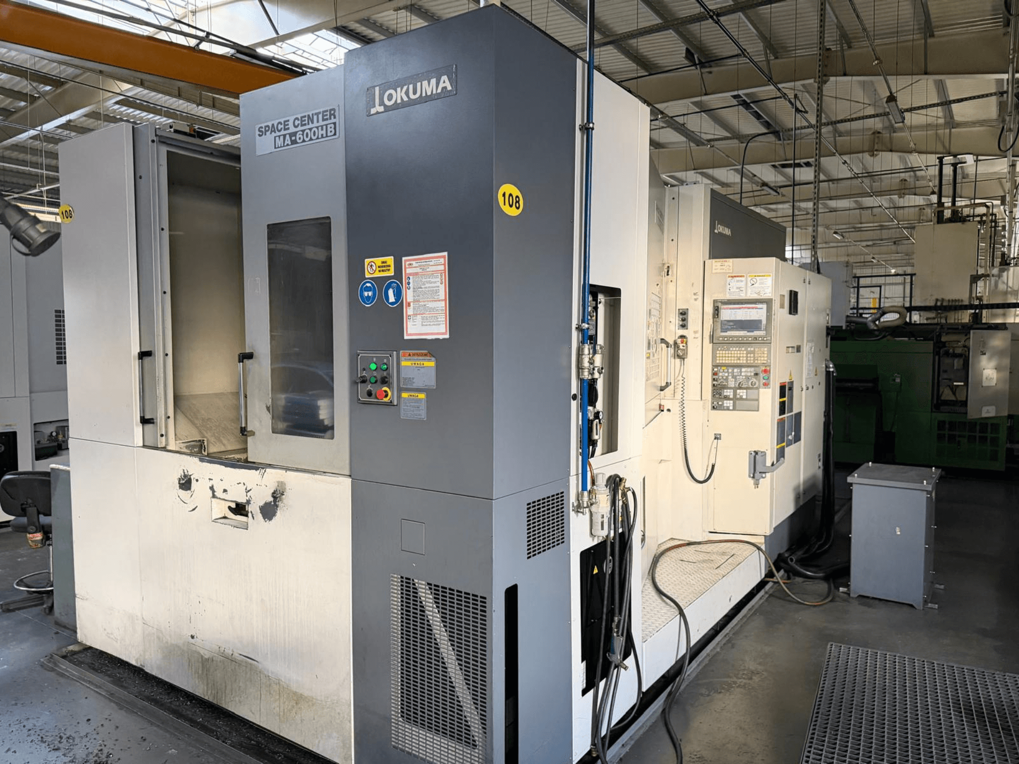 Okuma MA-600 HB Horizontal-Bearbeitungszentrum, Vorderansicht, mit Bedienfeld und Schneidbereich mit sichtbaren Verschleißspuren.