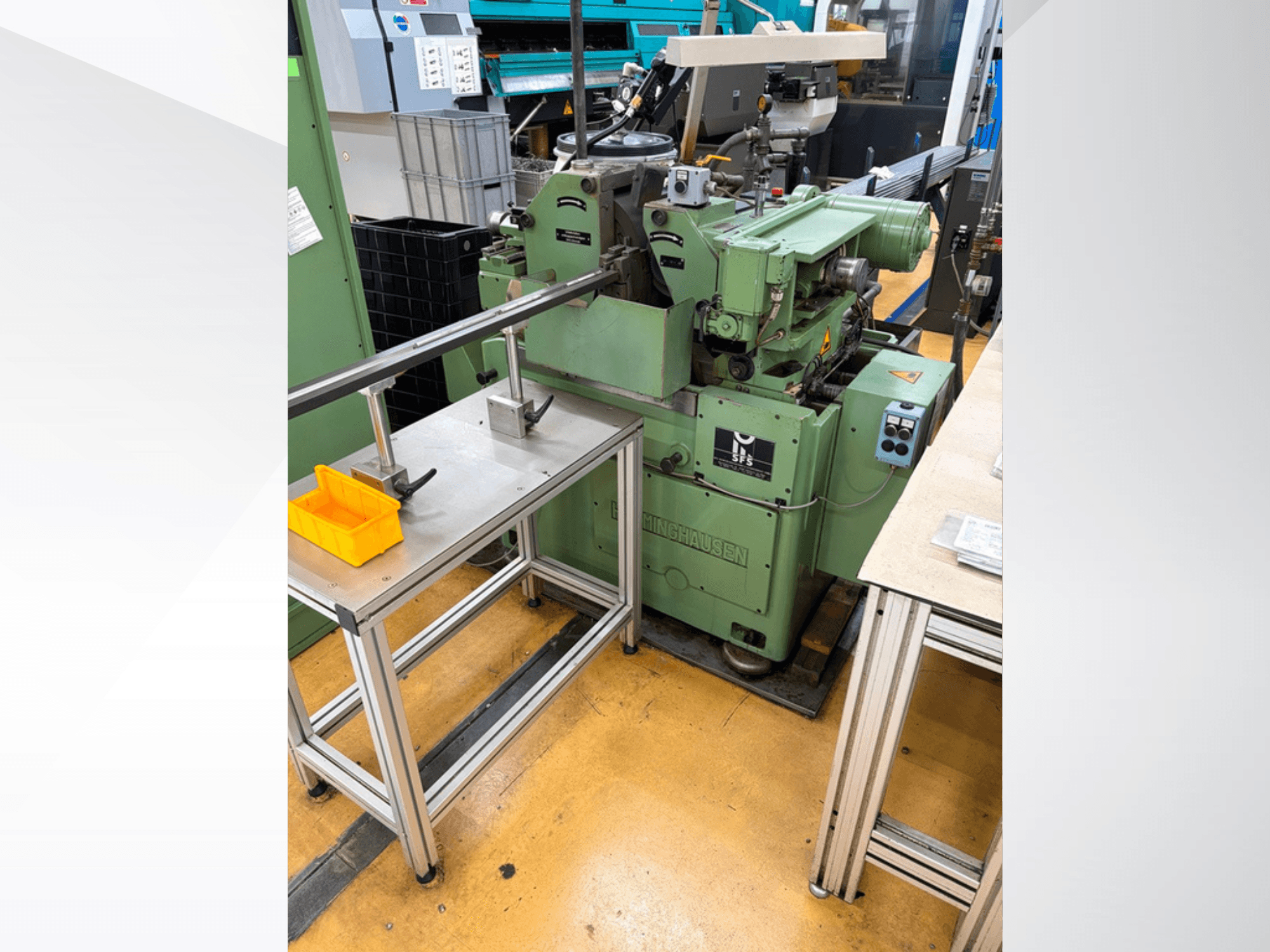 HERMINGHAUSEN SR 2 W spitzenlose Schleifmaschine in Grün, Vorderansicht, neben einem Metallarbeitstisch mit Werkzeugen aufgestellt.