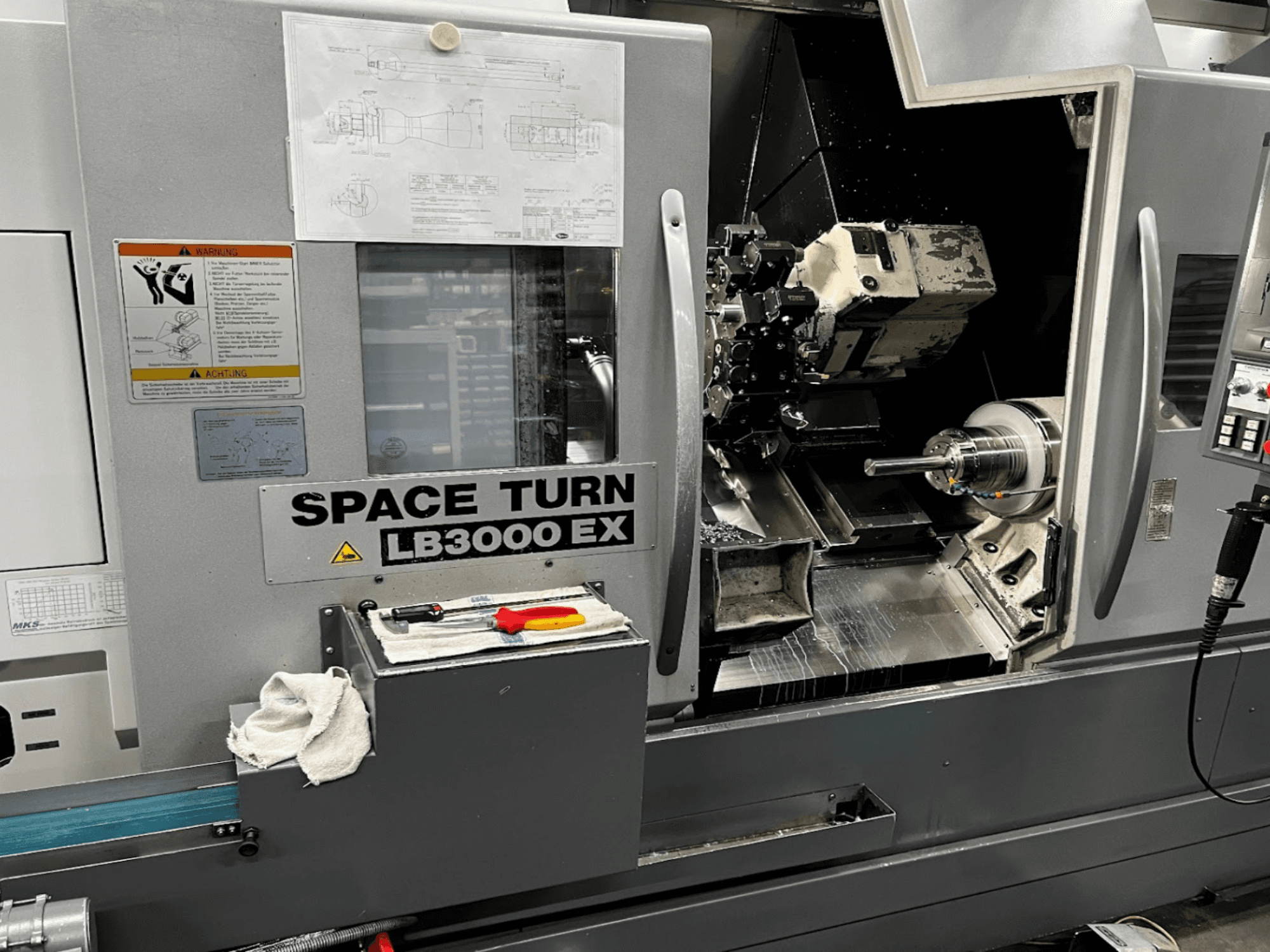 Okuma LB3000EX MYW Horizontal-Drehmaschine, Vorderansicht mit Bedienfeld, Werkzeugen und Details des Arbeitsbereichs sichtbar.