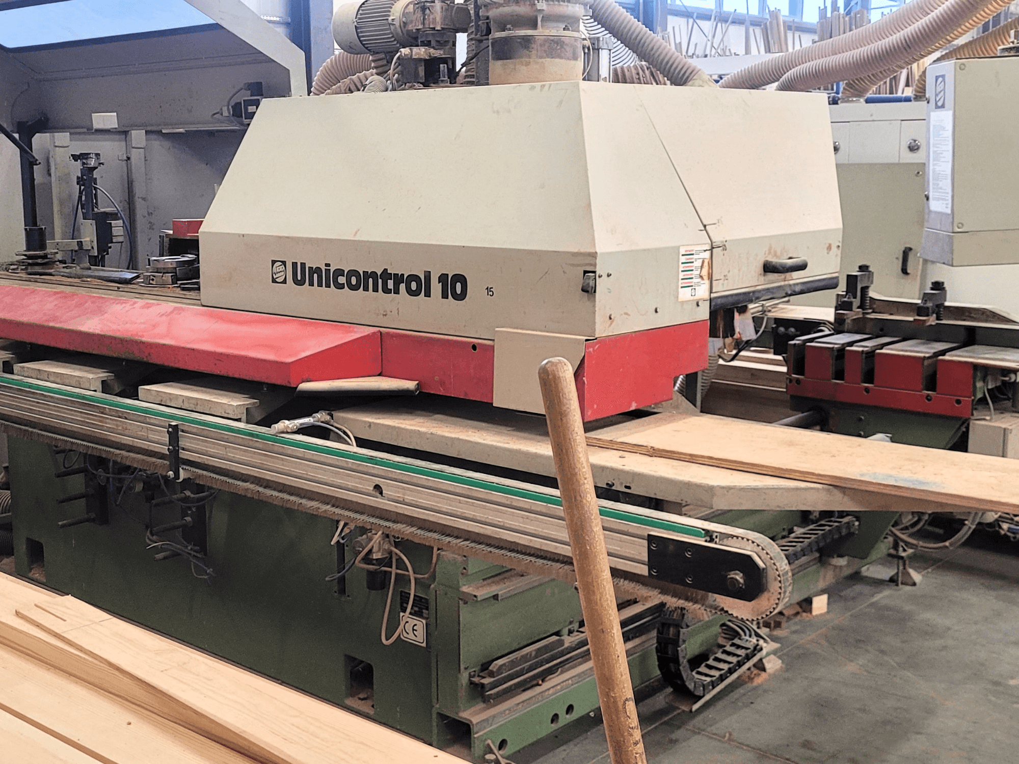 CNC-Bearbeitungszentrum Unicontrol 10 von WEINIG/DIMTER, Frontansicht mit Holzplatten und Geräten in einer Werkstattumgebung.