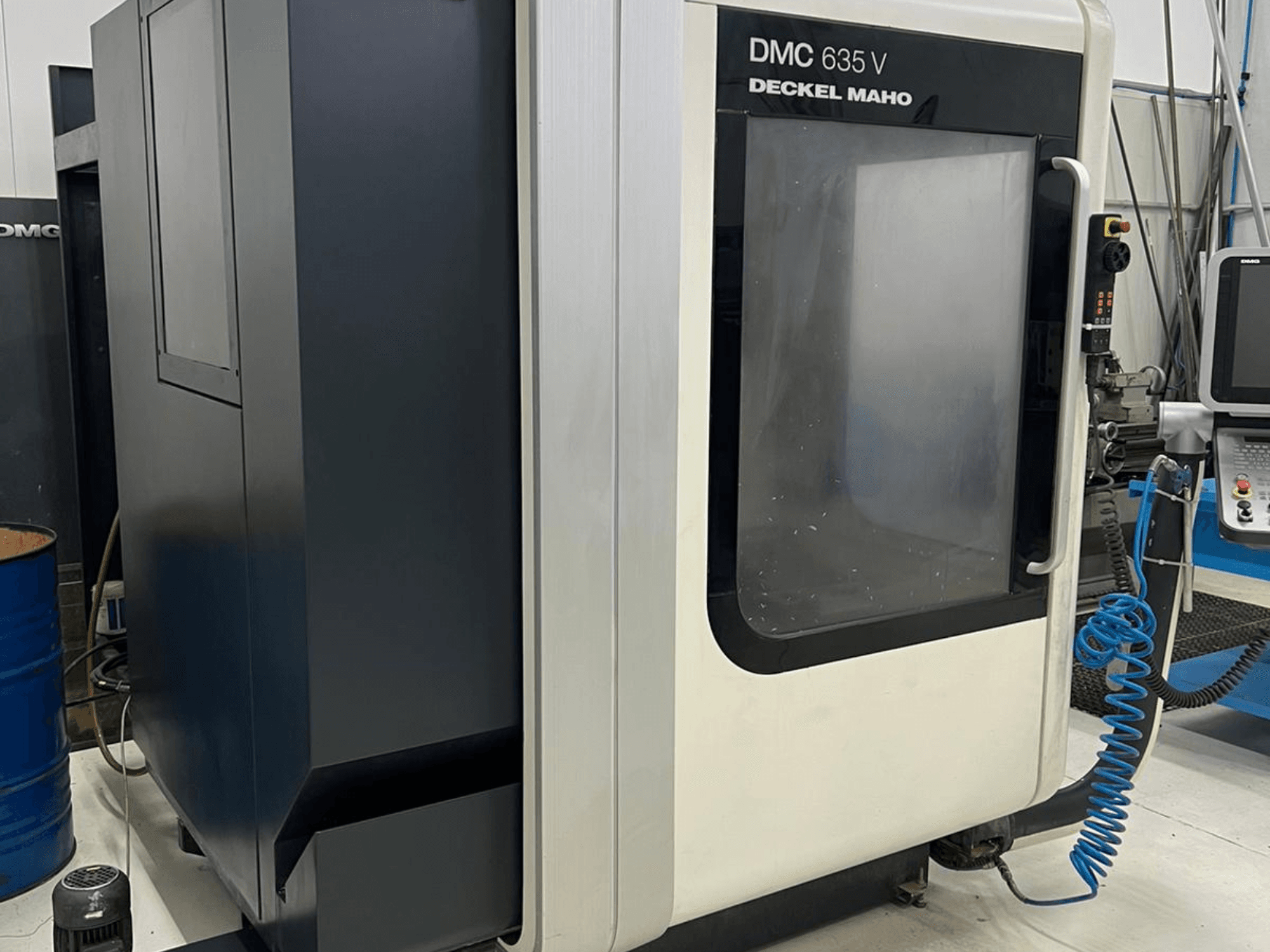 DMC 635 V Fräsmaschine von Deckel Maho, Seitenansicht mit Bedienfeld und teilweise geöffneter Zugangstür.