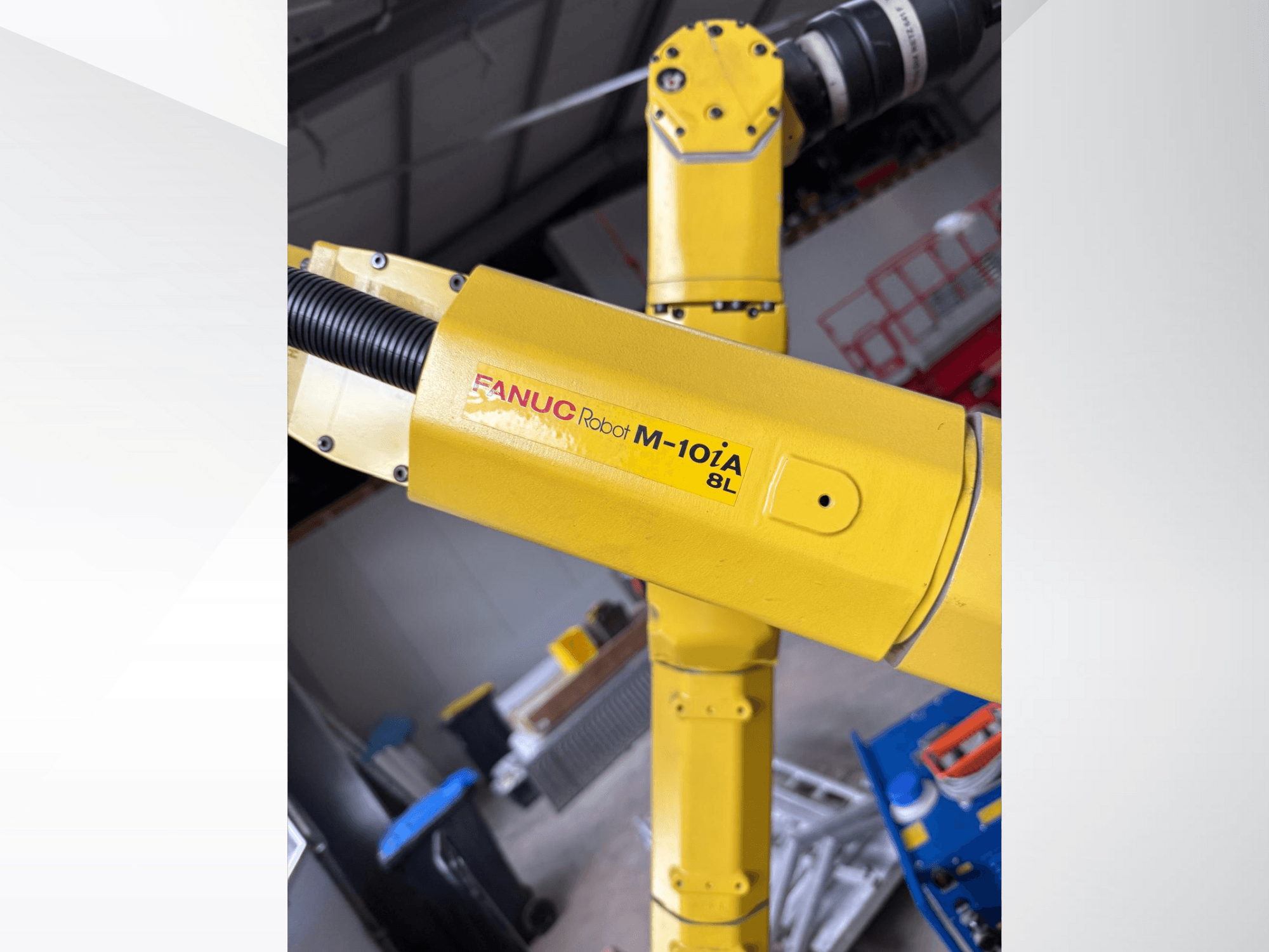 FANUC Roboter M-10iA 8L in gelb, von der Seite betrachtet, mit Armgelenk und mechanischen Komponenten in einer industriellen Umgebung.