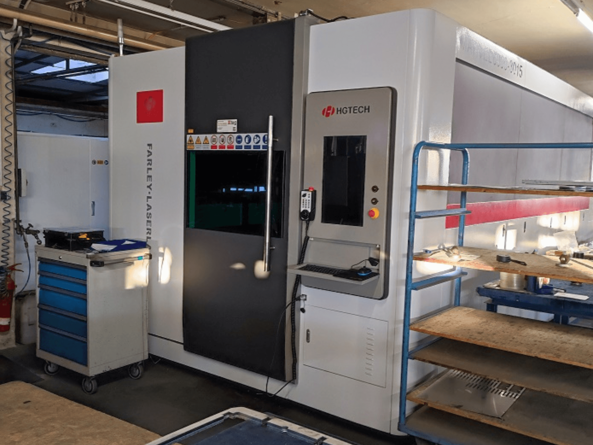 HGTECH Marvel 6000-3015 Faserlaserschneidmaschine, Frontansicht mit Bedienfeld und angrenzendem Lager.