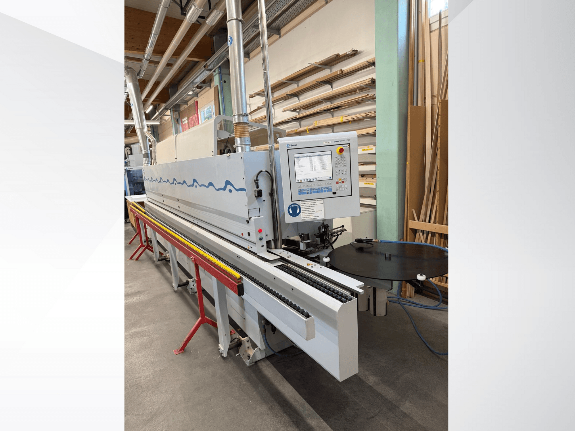 Frontansicht einer automatischen Kantenanleimmaschine von HolzHer mit Bedienpult, Transportsystem und rundem Auflagetisch.