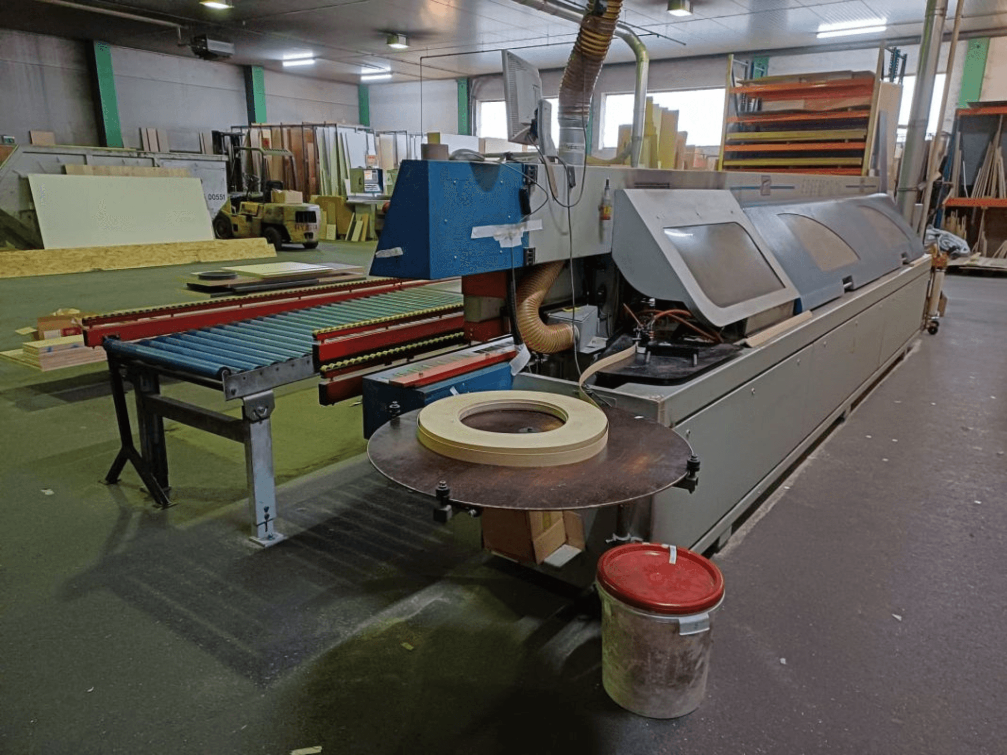 OTT TWISTER Kantenanleimmaschine in einer Werkstatt, mit Rollenbahn und Kreissäge, von der Seite gesehen.