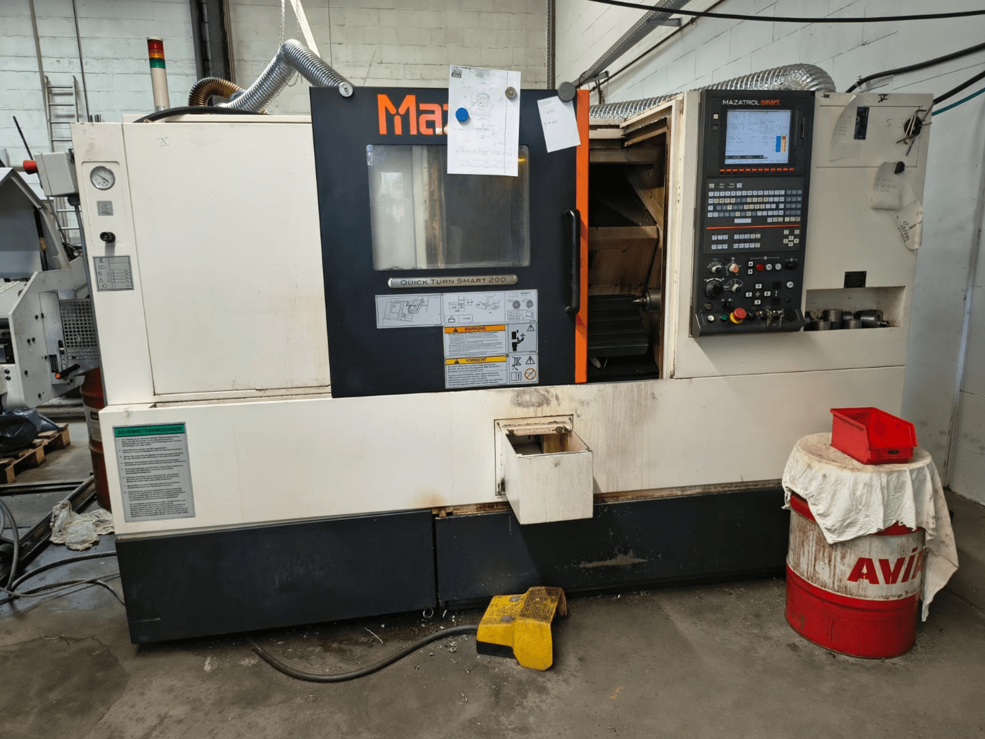 Mazak Quick Turn Smart 200, horizontale Drehmaschine, Vorderansicht mit Bedienfeld, Kühlmitteltank und sichtbaren Markierungen.
