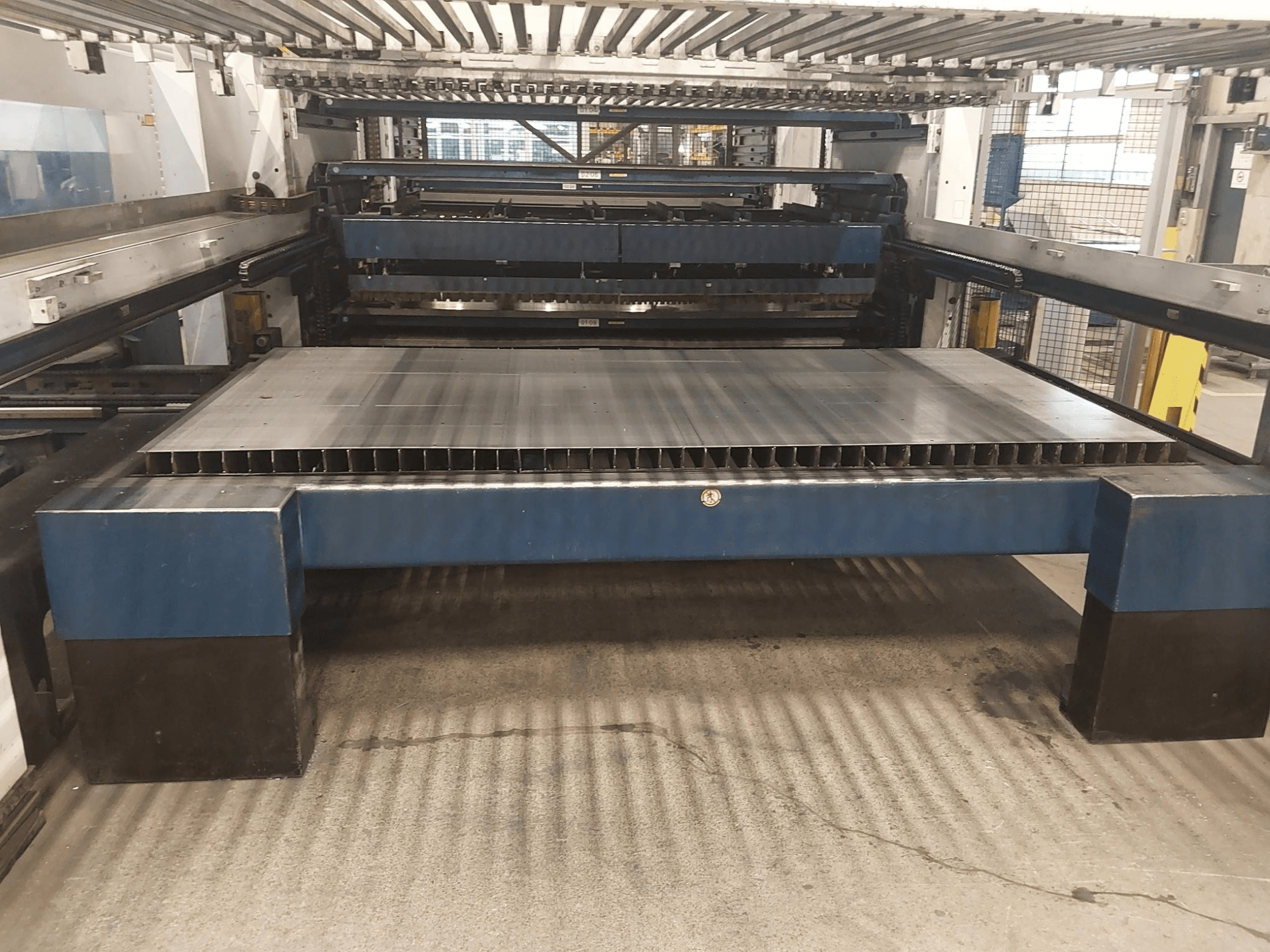 Frontansicht der TRUMPF TruLaser 3030 L20 CO2-Laserschneidanlage mit großem Schneidbett und Unterbau.