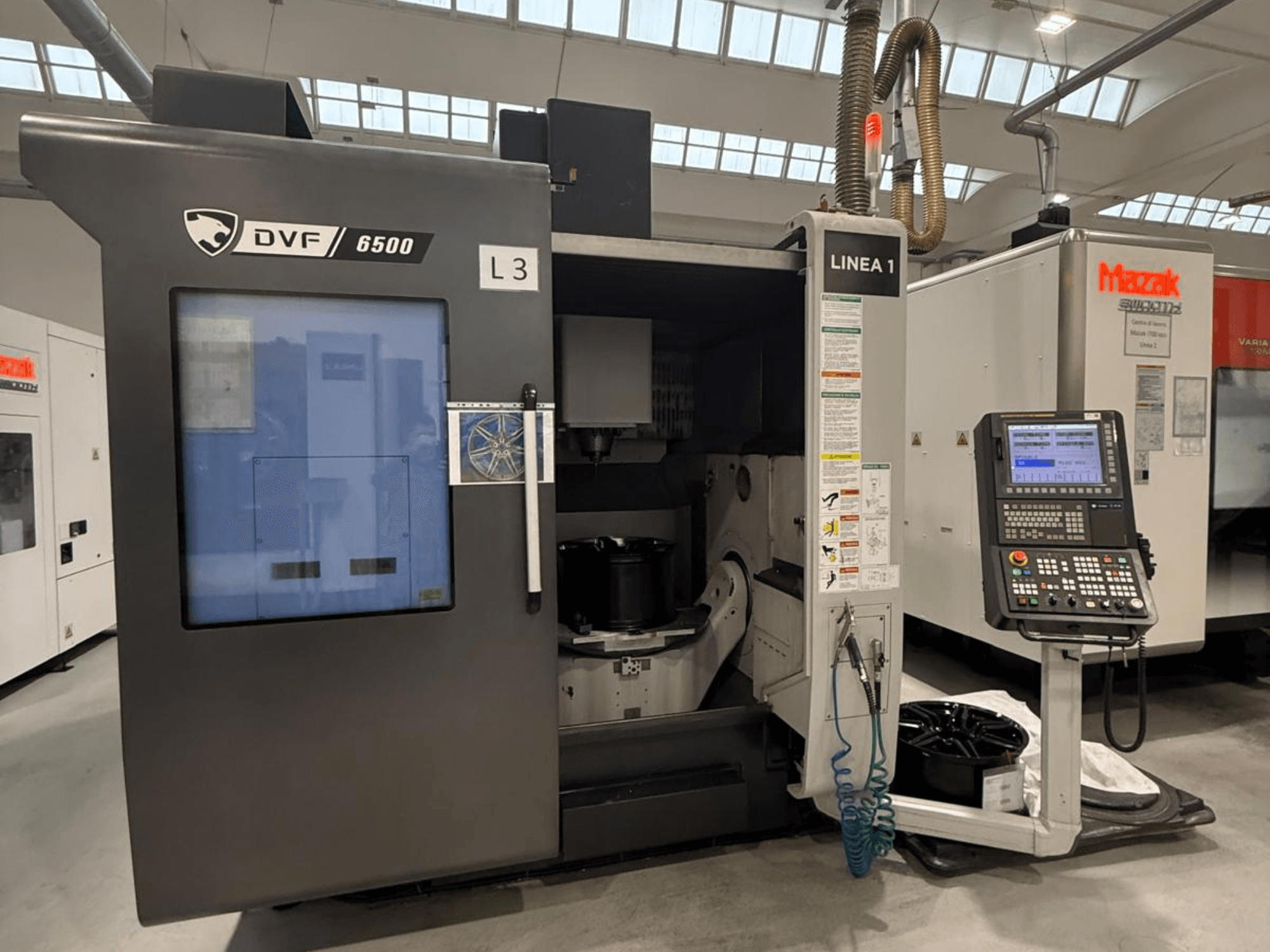CNC-Maschine DVF 6500, Vorderansicht, mit Bedienfeld und Innenraum mit Werkstückaufnahme.