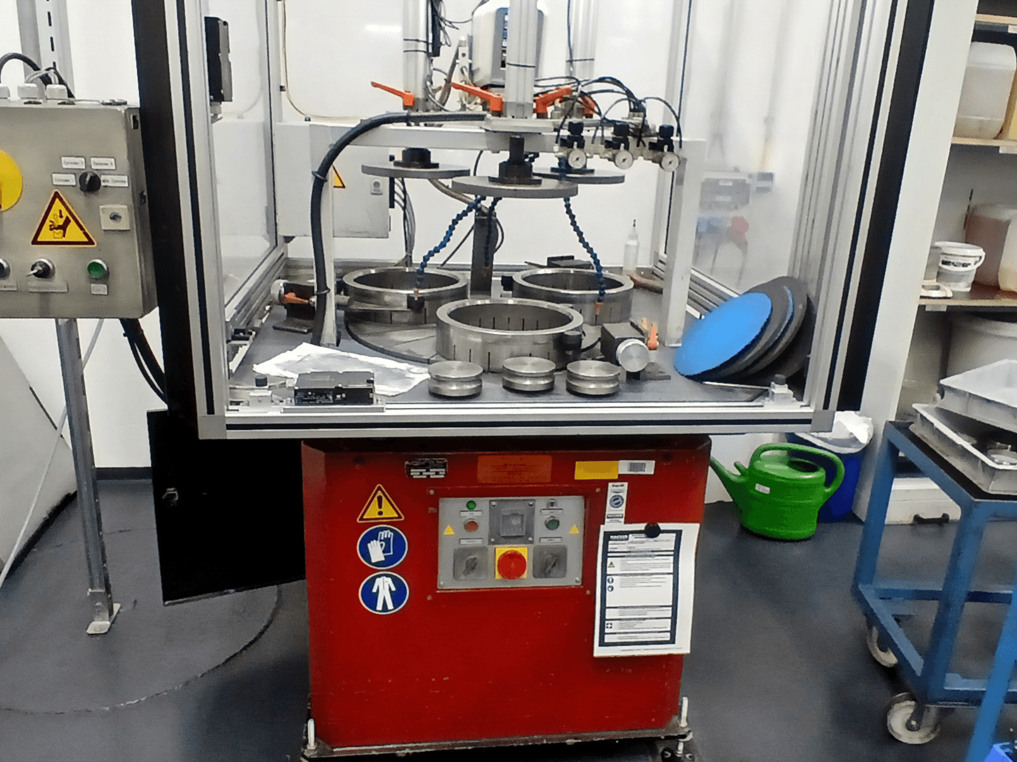 Werkzeugmaschine MYLÄP 700 in der Vorderansicht mit Bedienfeld, kreisförmigen Bauteilen und Sicherheitsmerkmalen auf einem roten Sockel.