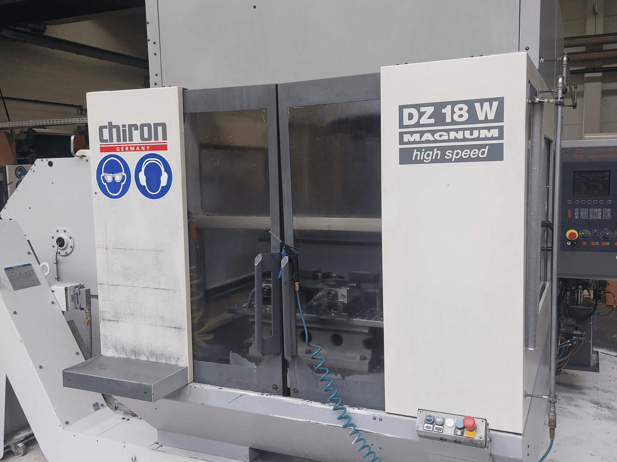 Vertikales Bearbeitungszentrum CHIRON DZ 18 W MAGNUM, Vorderansicht mit Bedienfeld und Sicherheitshinweisen.