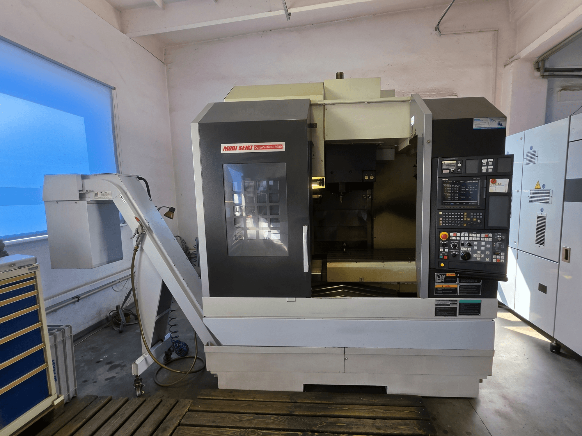 Vertikales Bearbeitungszentrum MORI SEIKI DuraVertical 5080, Vorderansicht mit Bedienfeld, Spindel und Werkzeughalter.