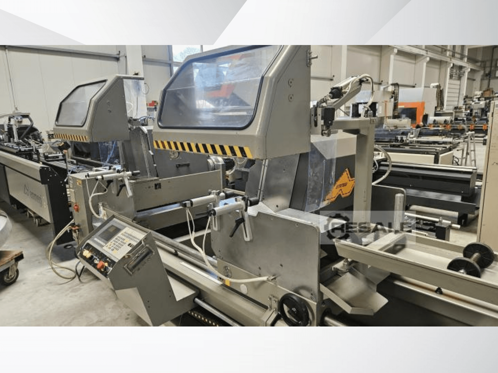 Doppelsägemaschinen in einer Werksumgebung; Vorderansicht mit Bedienfeld, Glasabdeckungen und Schneidkomponenten.