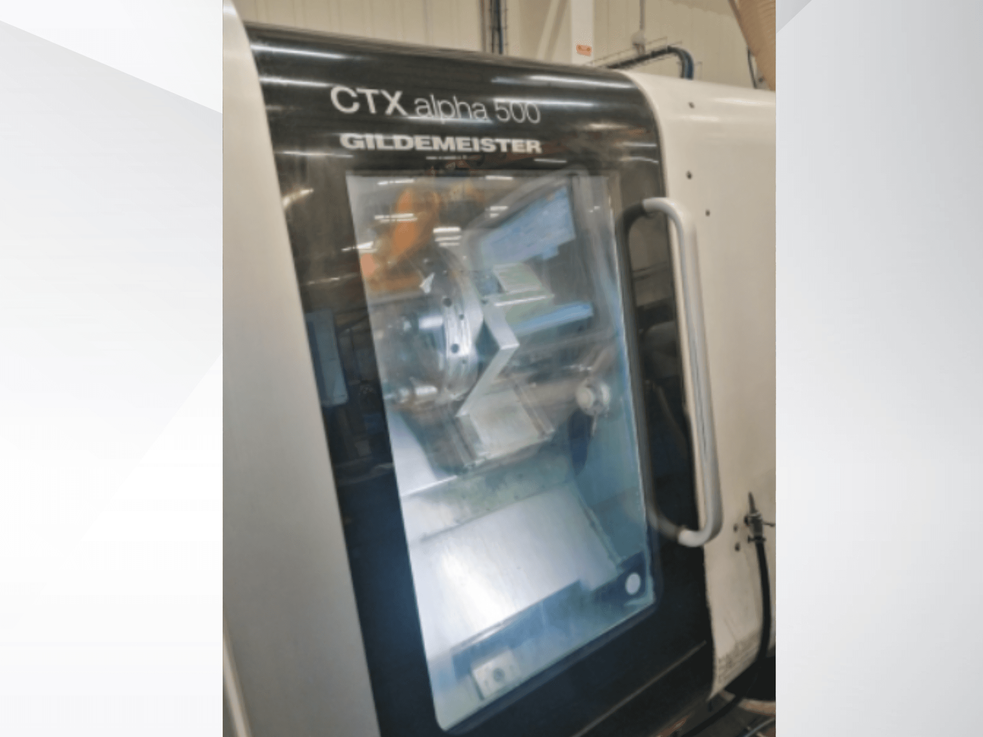 CTX alpha 500 Gildemeister CNC-Maschine, Vorderansicht mit Blick auf die Spindel und den Arbeitsraum durch die Glastür.
