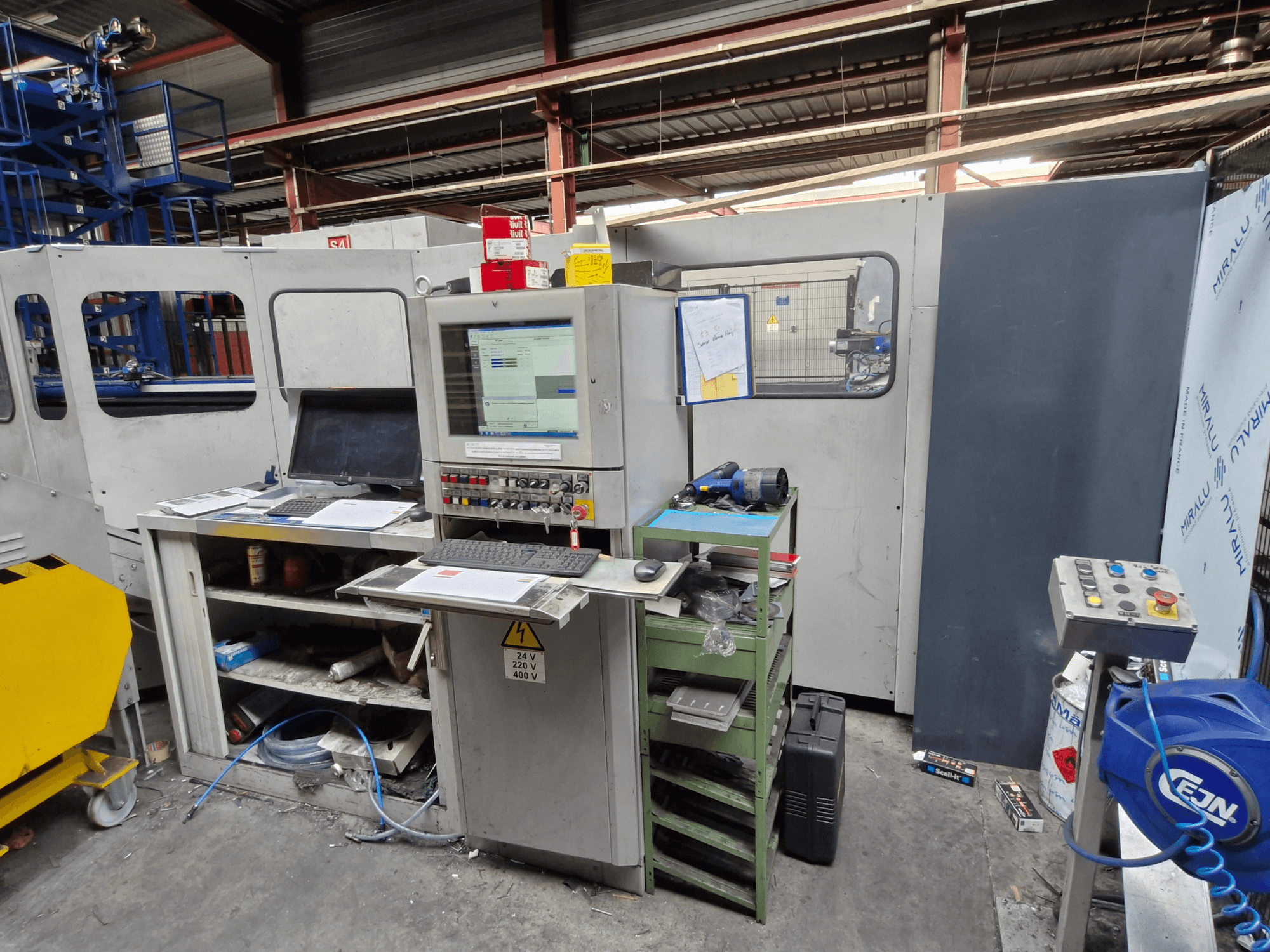 CNC-Stanzmaschine Salvagnini S4-40 in einer Werkstatt, mit einem Bedienpult mit Monitoren und Werkzeugen, Vorderansicht.