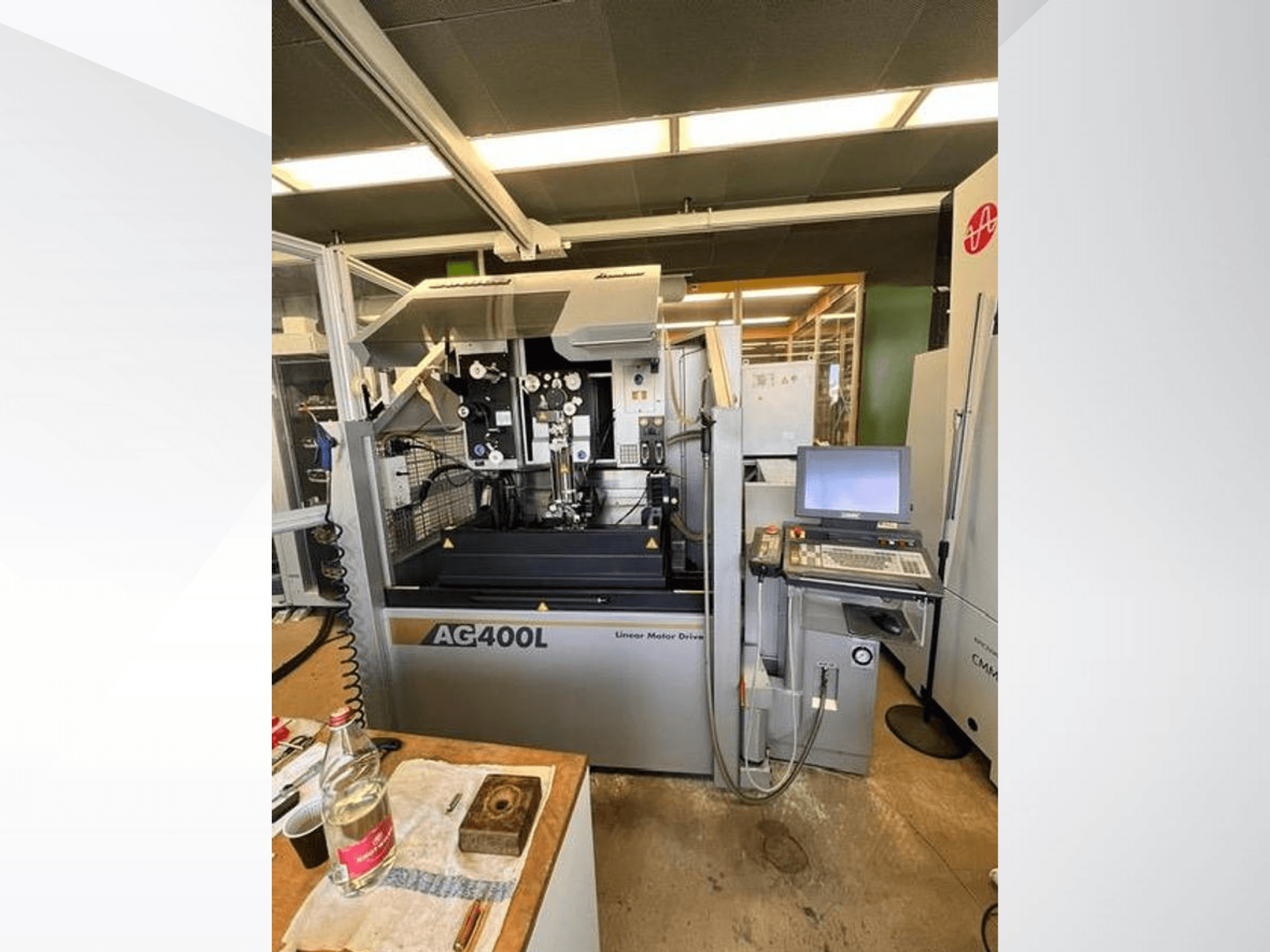 Maschine mit Linearmotorantrieb AG400L, Vorderansicht, mit Bedienfeld und Arbeitsbereich mit sichtbaren Sicherheitsmerkmalen.