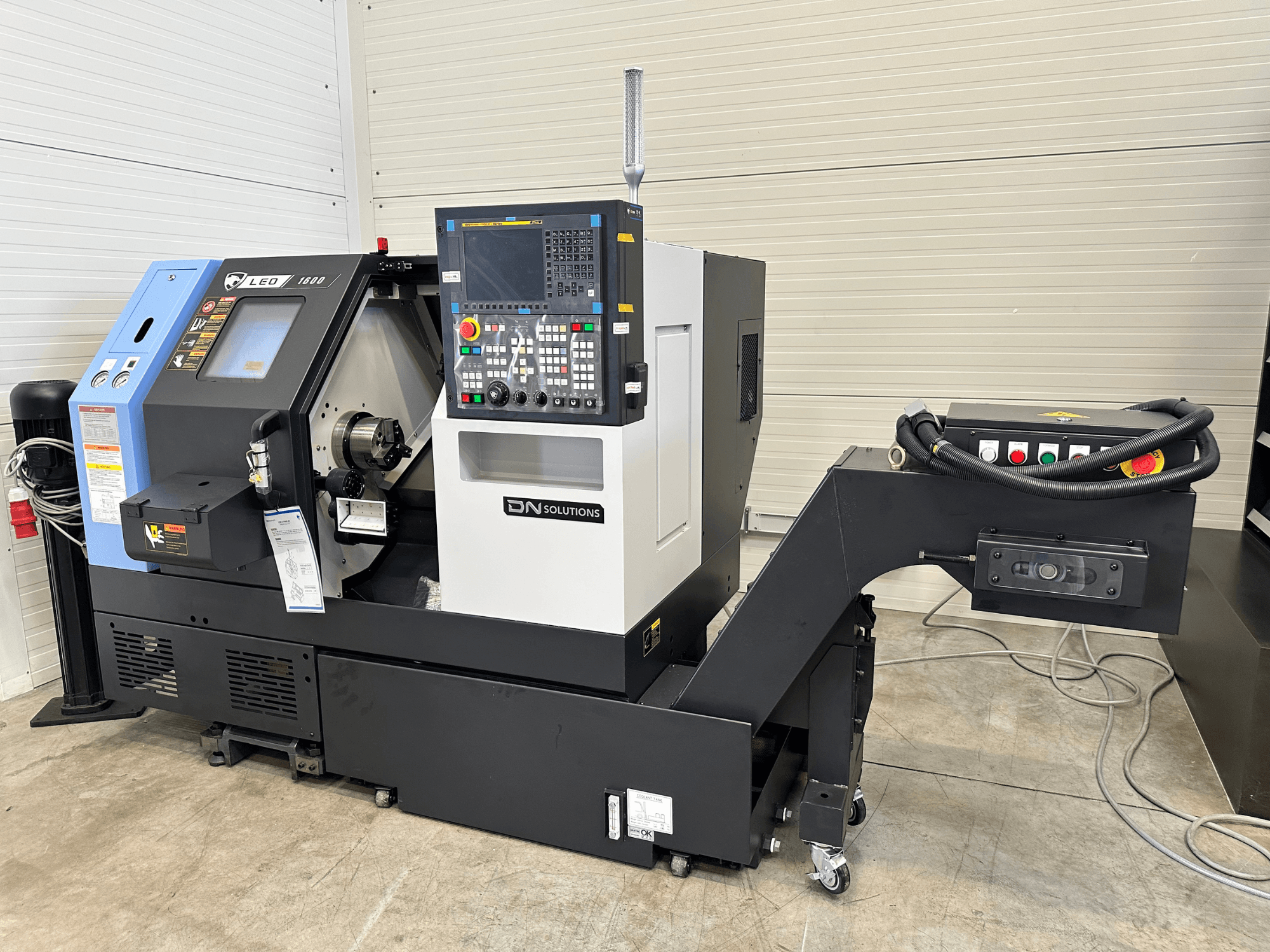 Frontansicht des DN SOLUTIONS Leo 1600 Dreh-Fräszentrums mit digitalem Bedienfeld und Werkzeughalter auf schwarzem Sockel.