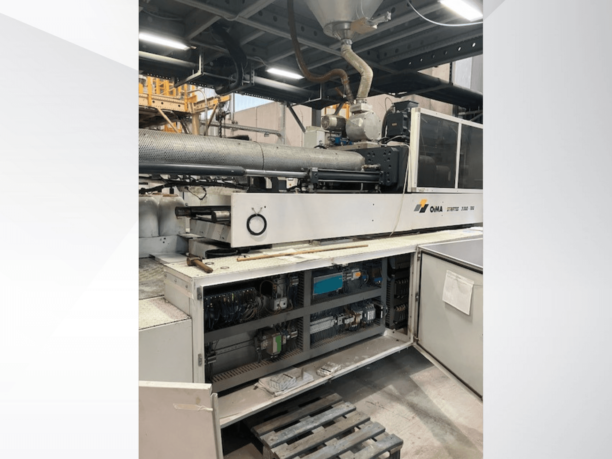 Vorderansicht des OMA Extruders 3500 mit den Betriebsteilen, der Schalttafel und den Details der Verkabelung. Schwere Maschinen in einer industriellen Umgebung.