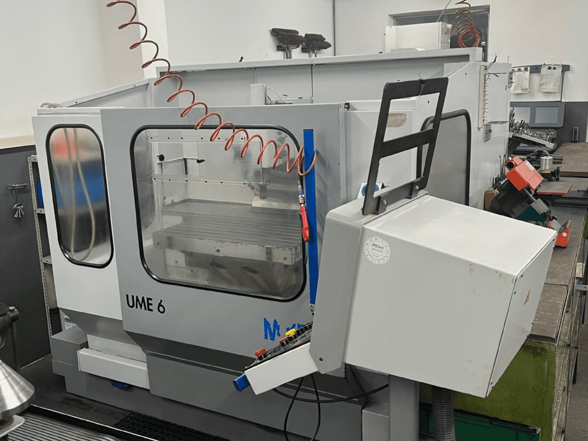 MIKRON UME600 Universal-Bearbeitungszentrum in einer Werkstatt, Seitenansicht mit Bedienfeld und Schutzabdeckung.