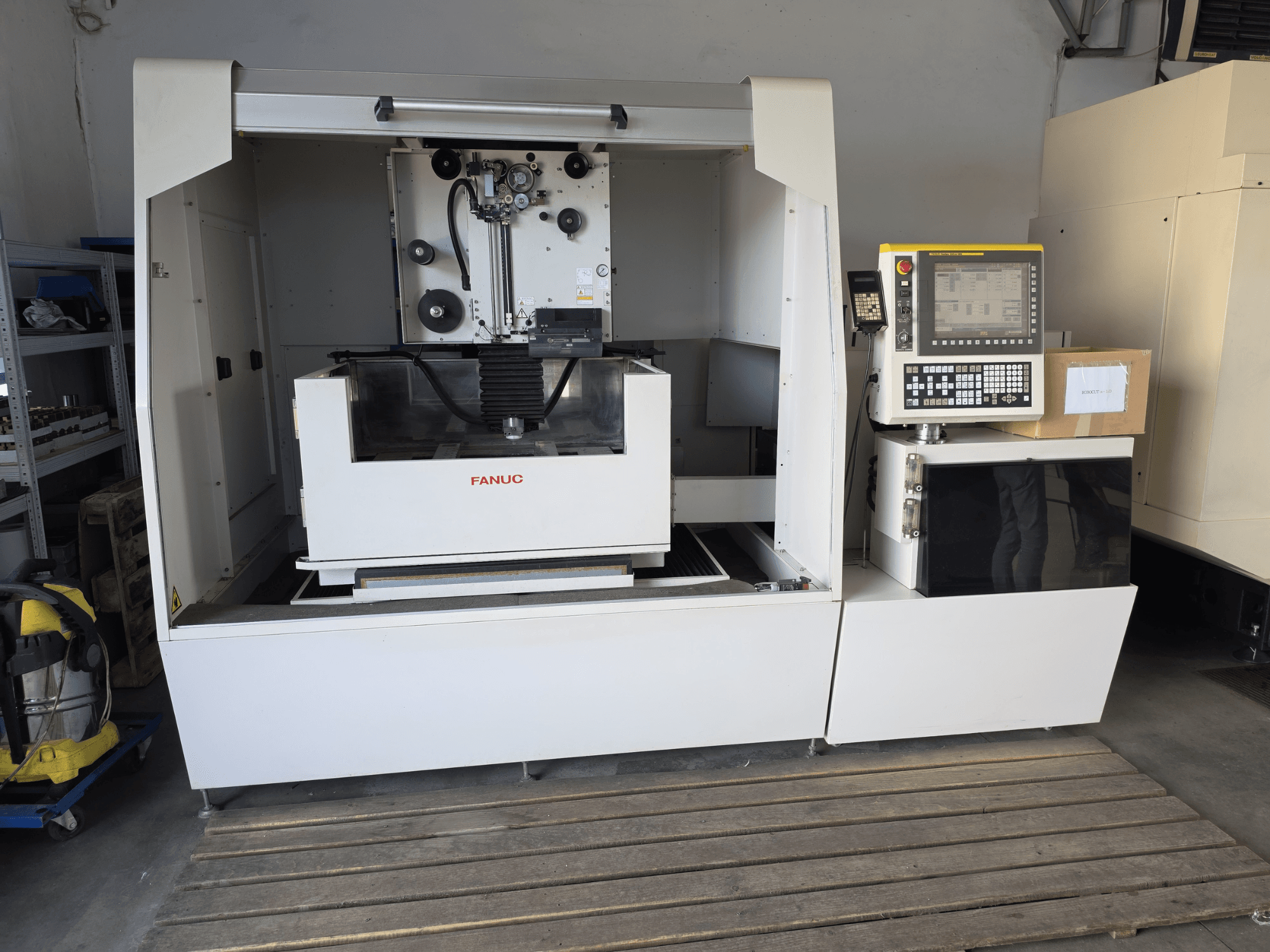 FANUC ROBOCUT alpha-1iD Drahterodiermaschine, Vorderansicht mit Bedienfeld, Arbeitsbereich und kompakter Bauweise in einer Werkstattumgebung.