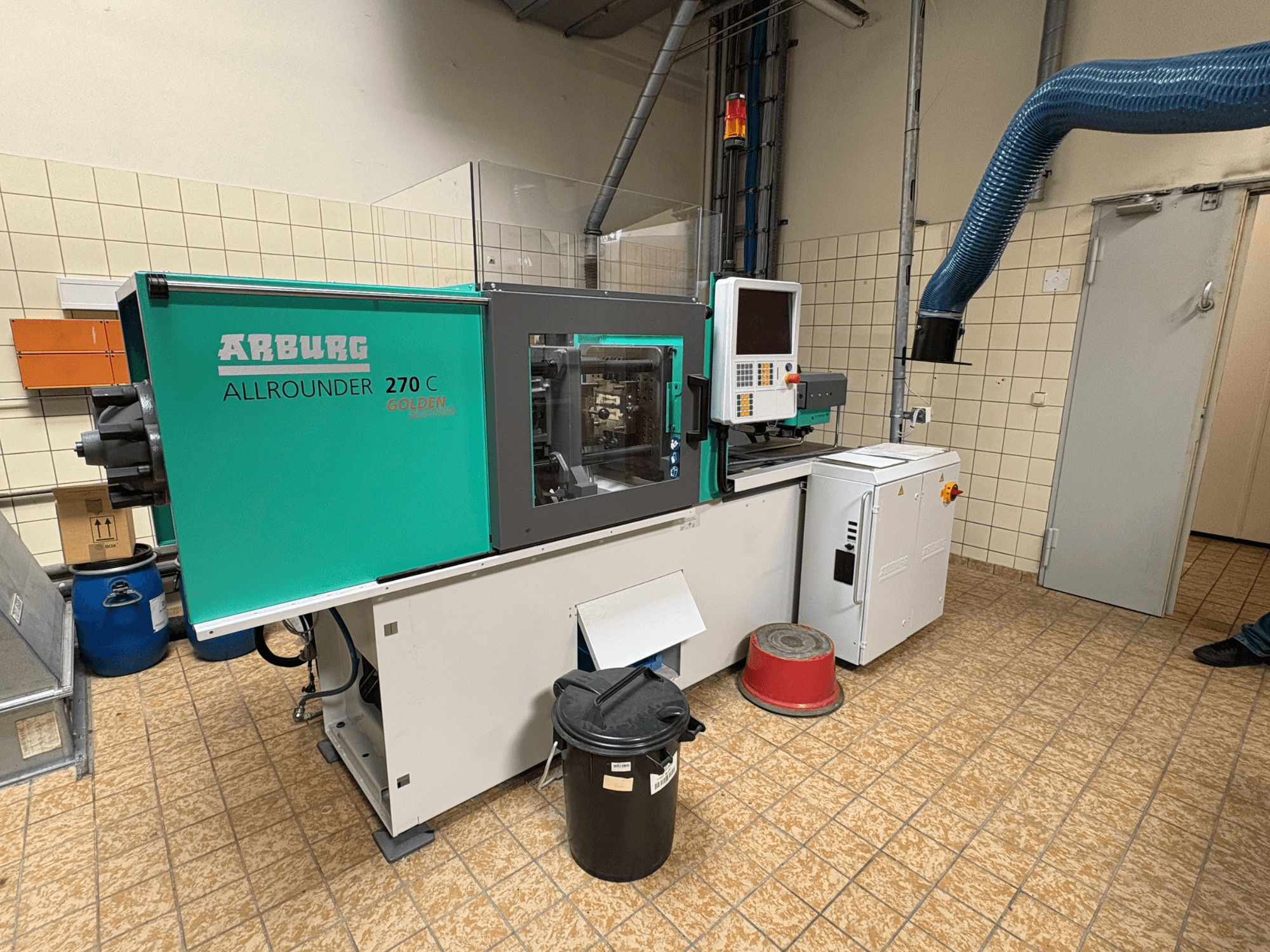 Hydraulische Spritzgießmaschine Arburg ALLROUNDER 270 C in Seitenansicht, mit Bedienelementen und angeschlossenen Geräten.