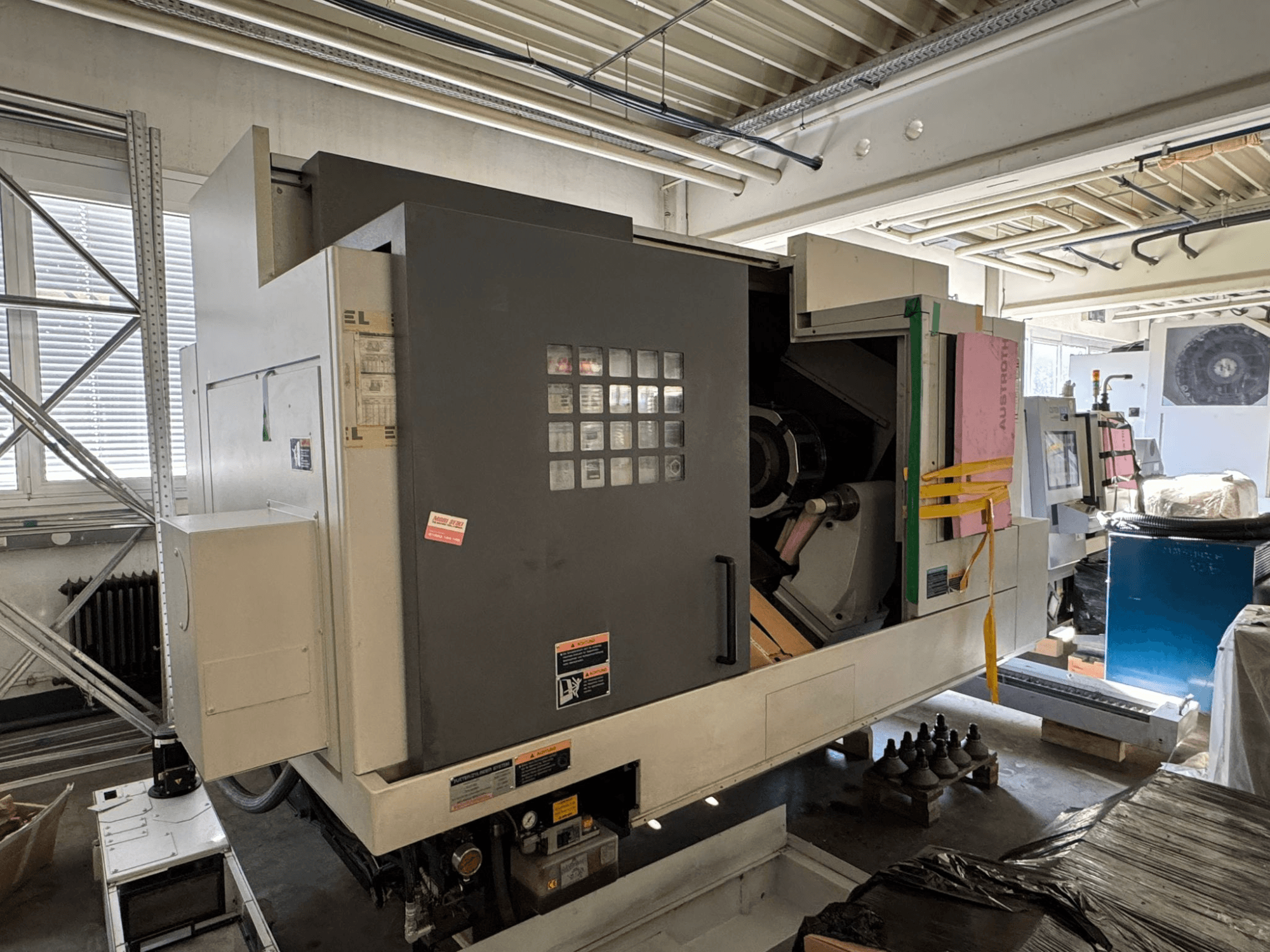 Horizontaldrehmaschine MORI SEIKI NL 3000 MC/700, Vorderansicht mit Bedienfeld, Ablagebereich und Schutzhülle.