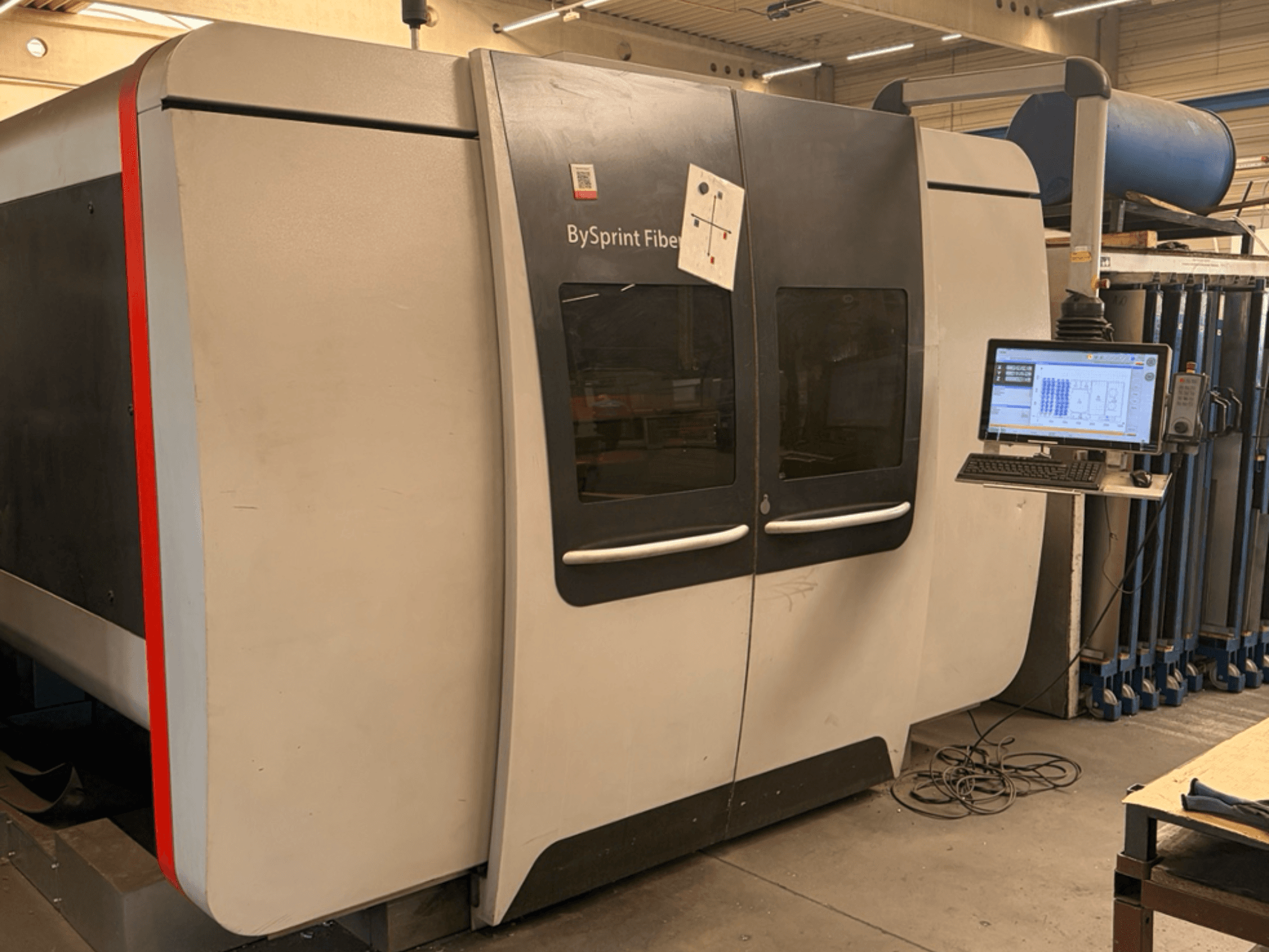 Bystronic BySprint Fiber 3015, Vorderansicht einer Faserlaserschneidemaschine mit Touchscreen-Bedienfeld und industrieller Umgebung.