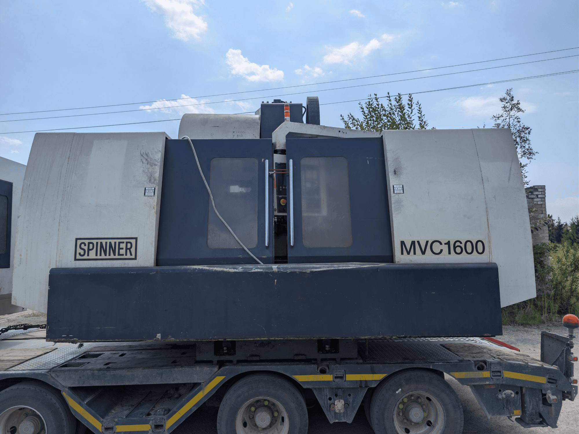 Vertikales Bearbeitungszentrum SPINNER MVC 1600, Vorderansicht auf einem Lkw, mit Markenlogo und großem Bearbeitungsbereich.