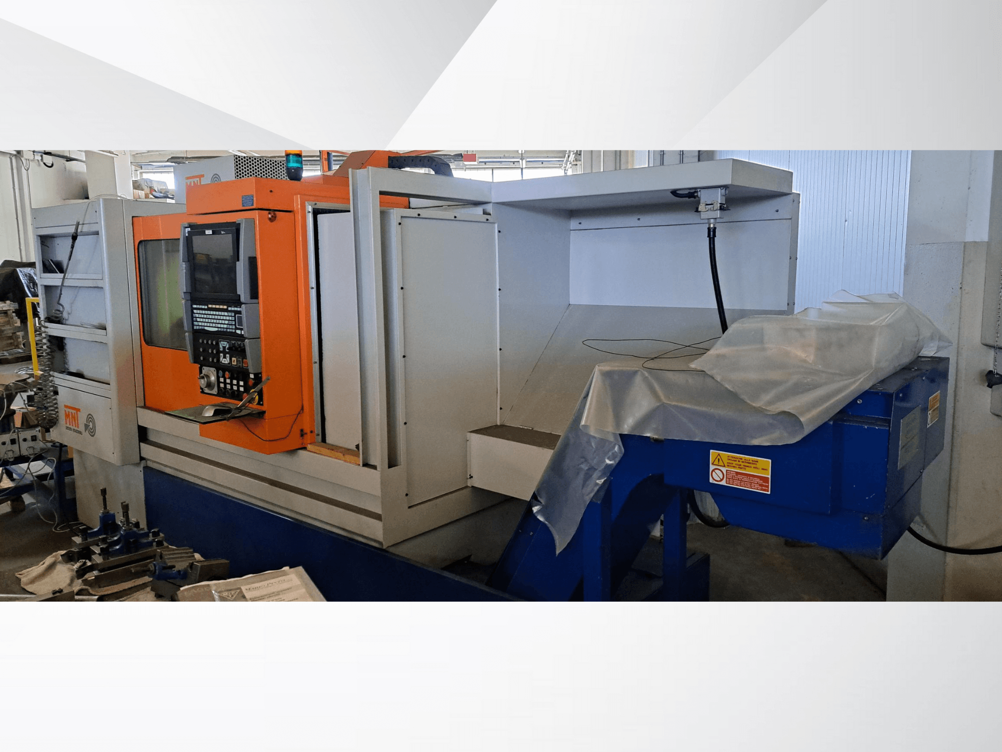 MNT CNC-Maschine, Vorderansicht, mit orangefarbenem Bedienfeld, großem Bearbeitungsbereich und blauer Späneentsorgungseinheit.