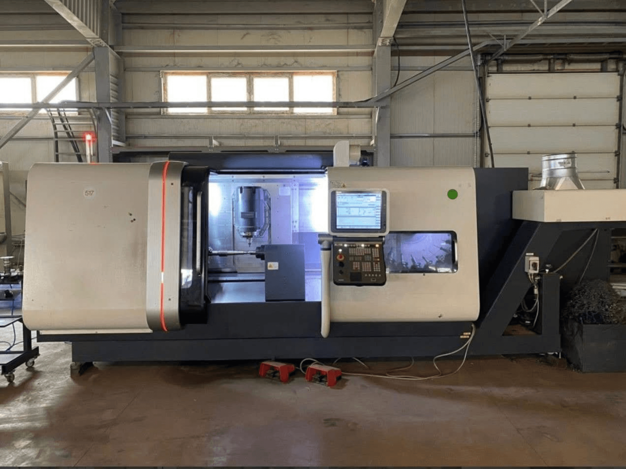 DMG MORI Beta 1250 TC Dreh-Fräszentrum, Vorderansicht mit Bedienfeld, beleuchtetem Arbeitsbereich und sichtbaren Schneidwerkzeugen.