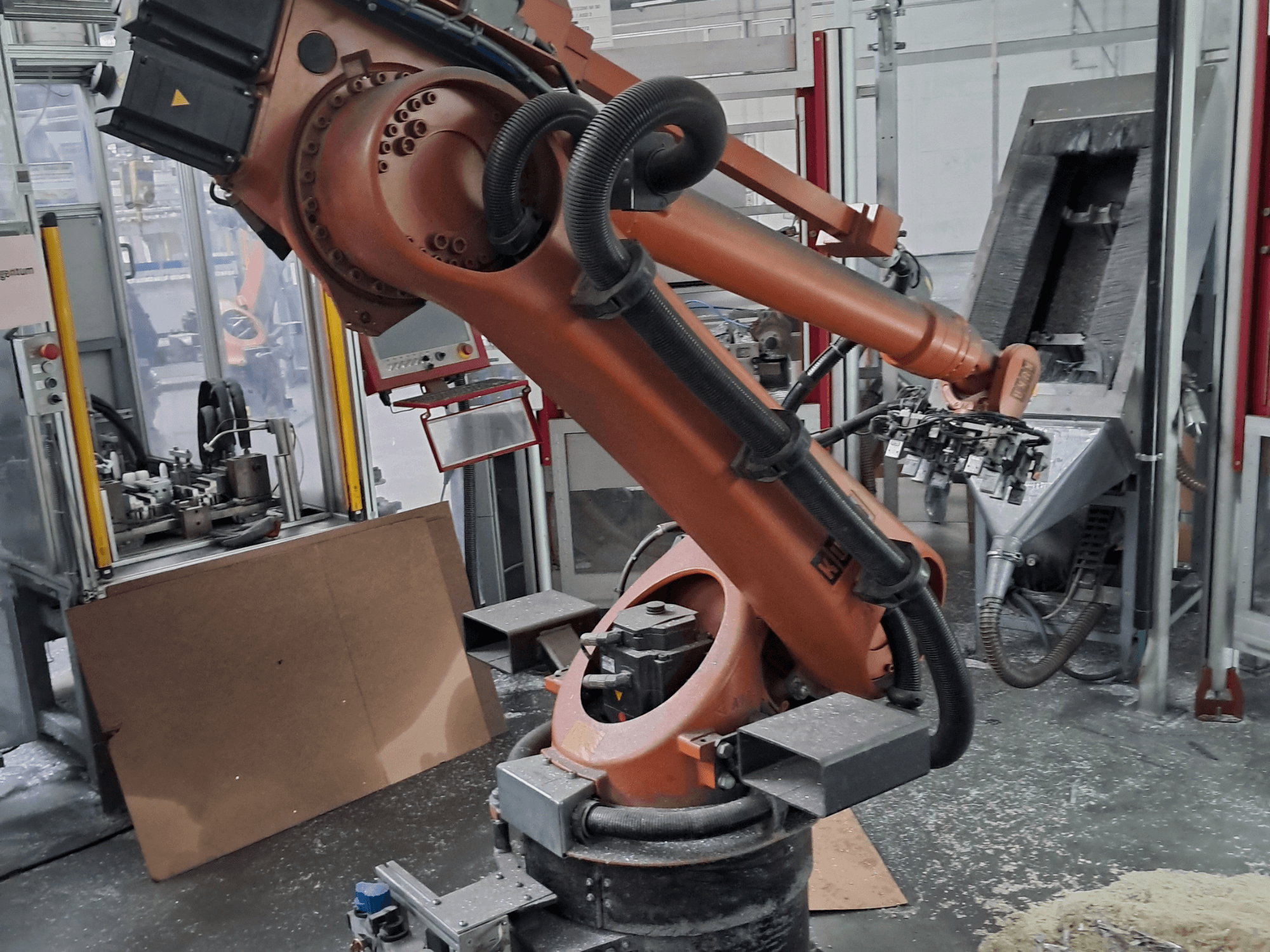 KUKA KR 30 L 16-2-Roboterarm in einer Werkstatt, Vorderansicht. Mit Gelenken und einem industriellen Arbeitsbereich im Hintergrund.