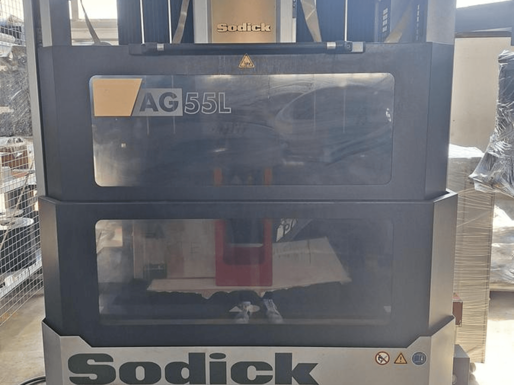 Sodick AG 55L Senkerodiermaschine, Frontansicht mit Bedienelementen, die durch transparente Scheiben sichtbar sind und den Arbeitsbereich im Inneren zeigen.