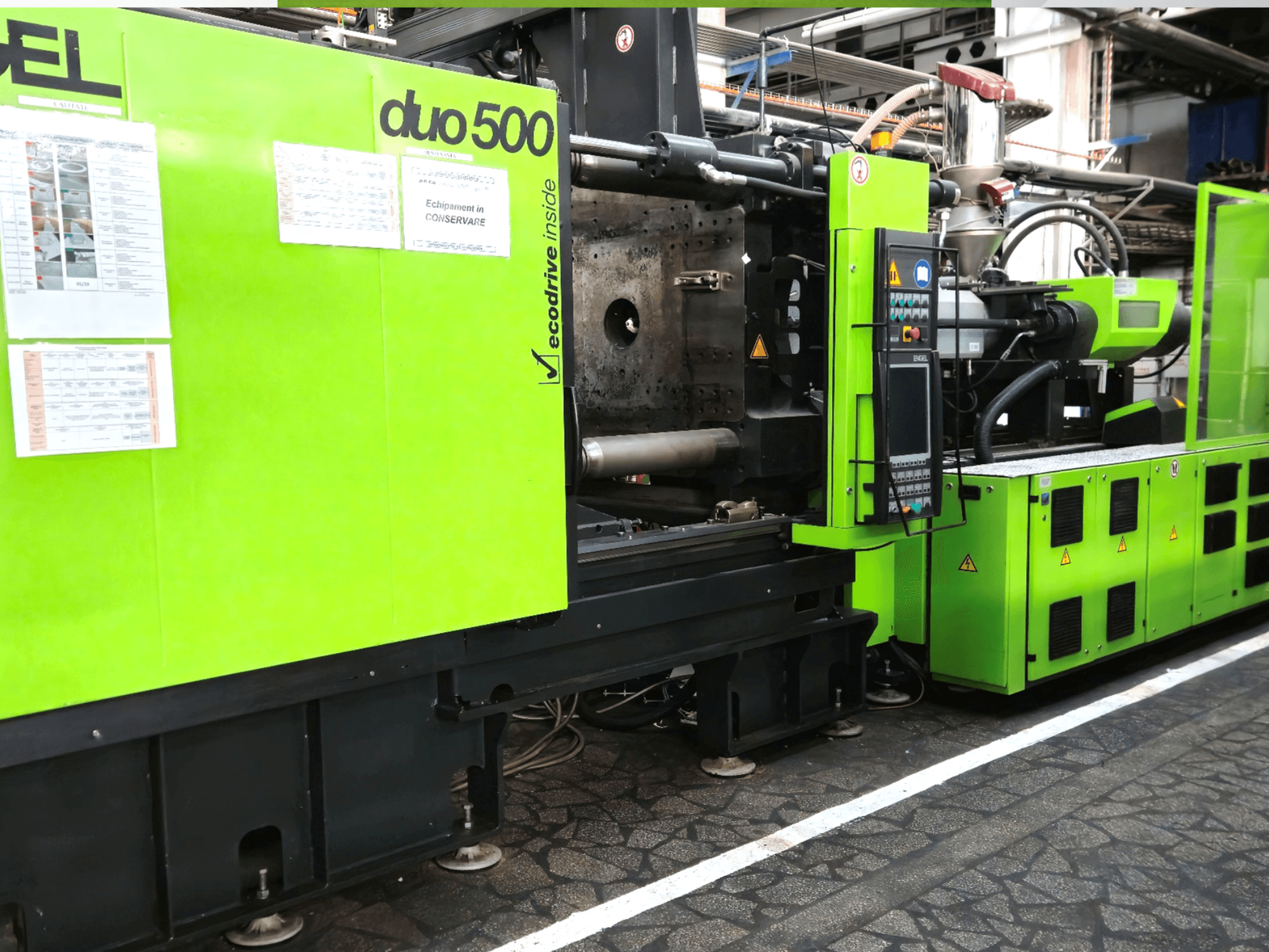 Grüne Industriemaschine Ergotron duo 500, Vorderansicht; mit Bedienfeld, technischen Details und Sicherheitsetiketten der Geräte.