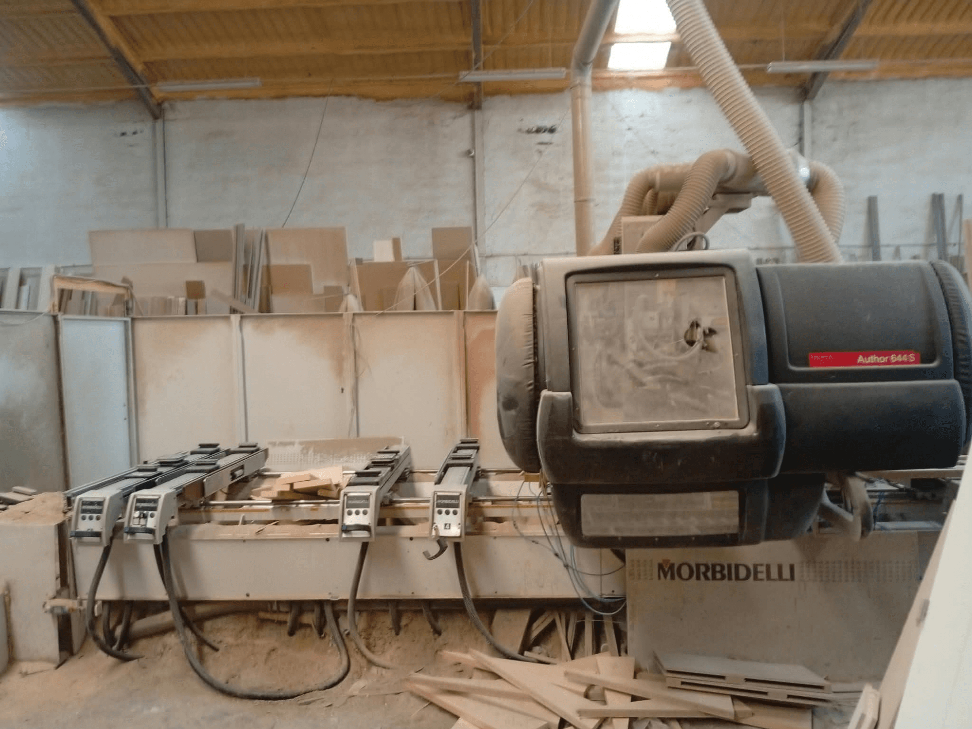 CNC-Bearbeitungszentrum MORBIDELLI A644S FTP 41 PC, ausgestellt in einer Werkstatt, Frontansicht mit Staub und Holzspänen.
