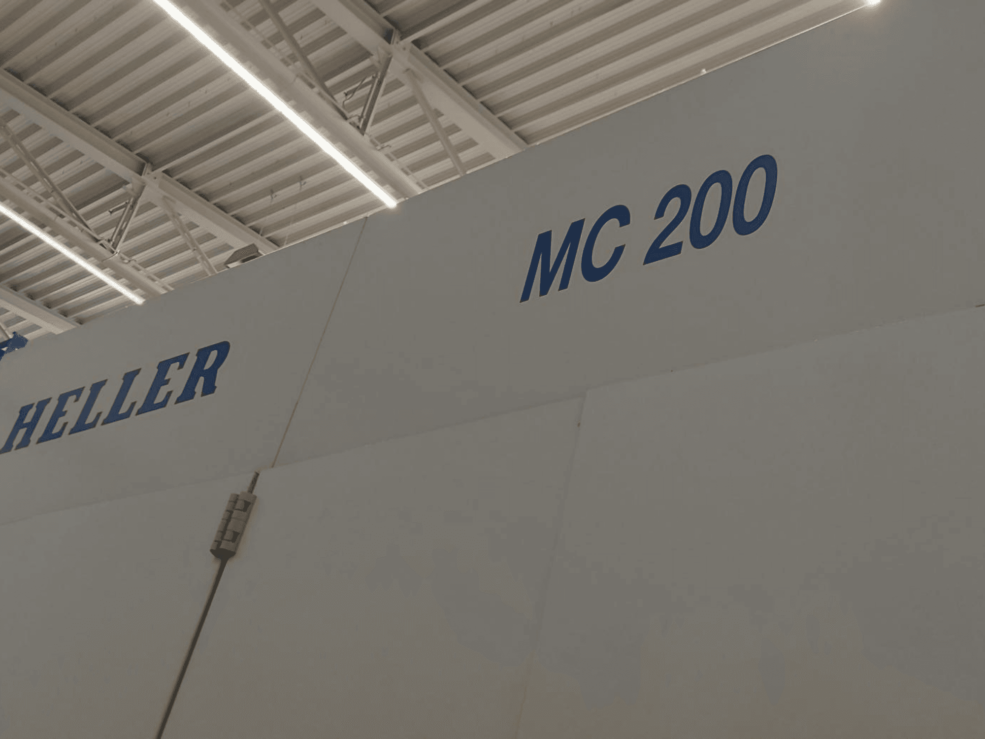 Heller MC 200 Horizontal-Bearbeitungszentrum, von der Seite betrachtet, mit blauer Marken- und Modellbezeichnung auf weißer Fläche.