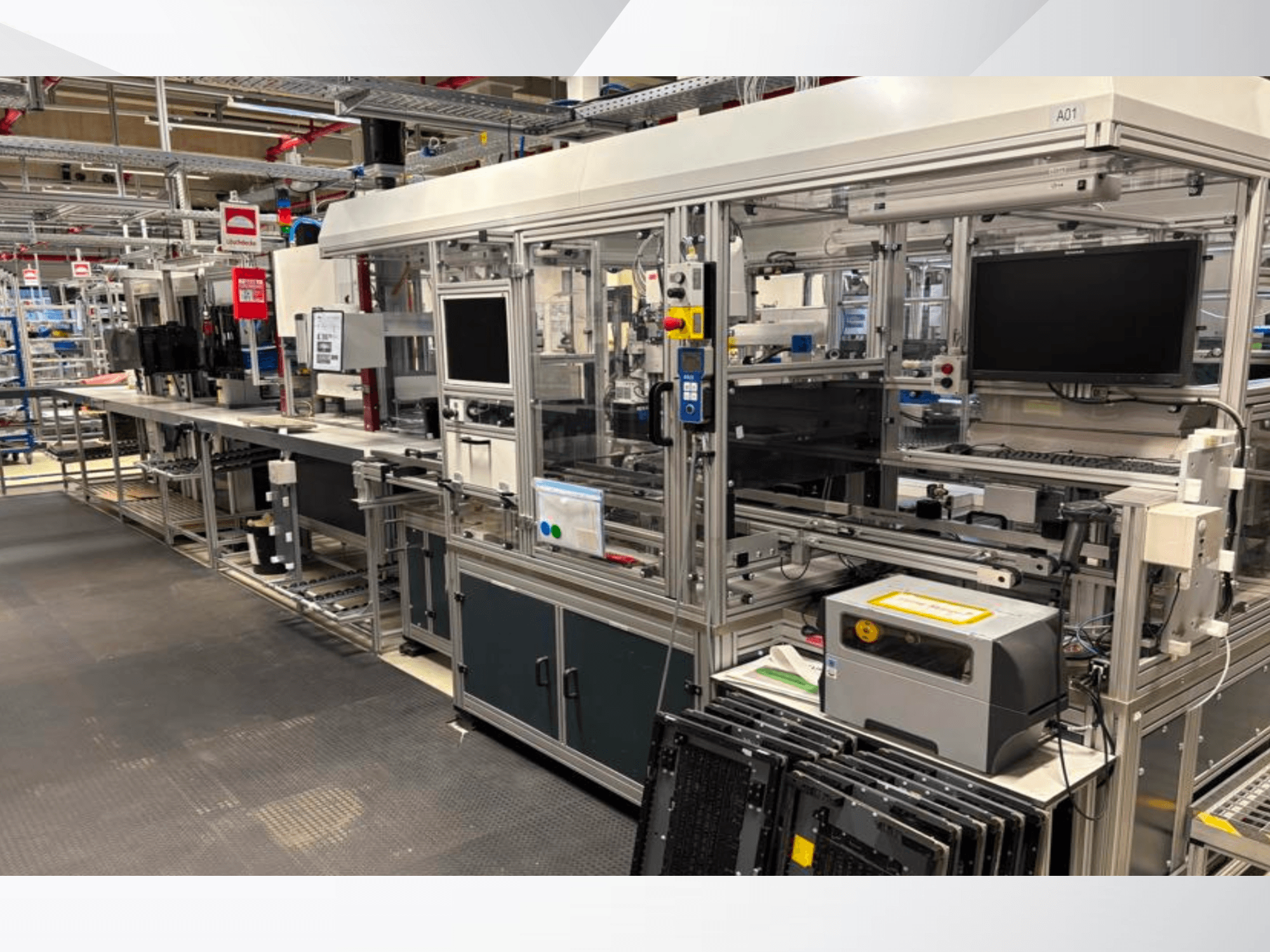 Aufbau der AMADA Jupiter System-Automatisierungsanlage in Seitenansicht, mit Bildschirmen, Bedienfeldern und Maschinenkomponenten.
