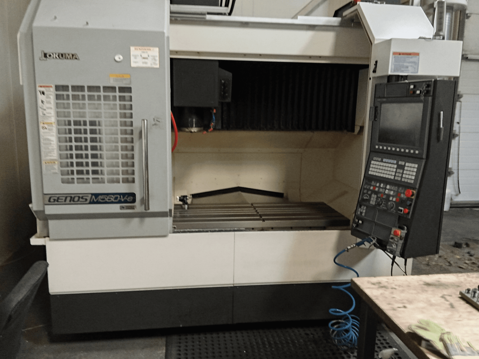 Okuma GENOS M560-V, Frontansicht eines vertikalen Bearbeitungszentrums mit Bedienfeld, CNC-Schnittstelle und sichtbarem Schneidbereich.