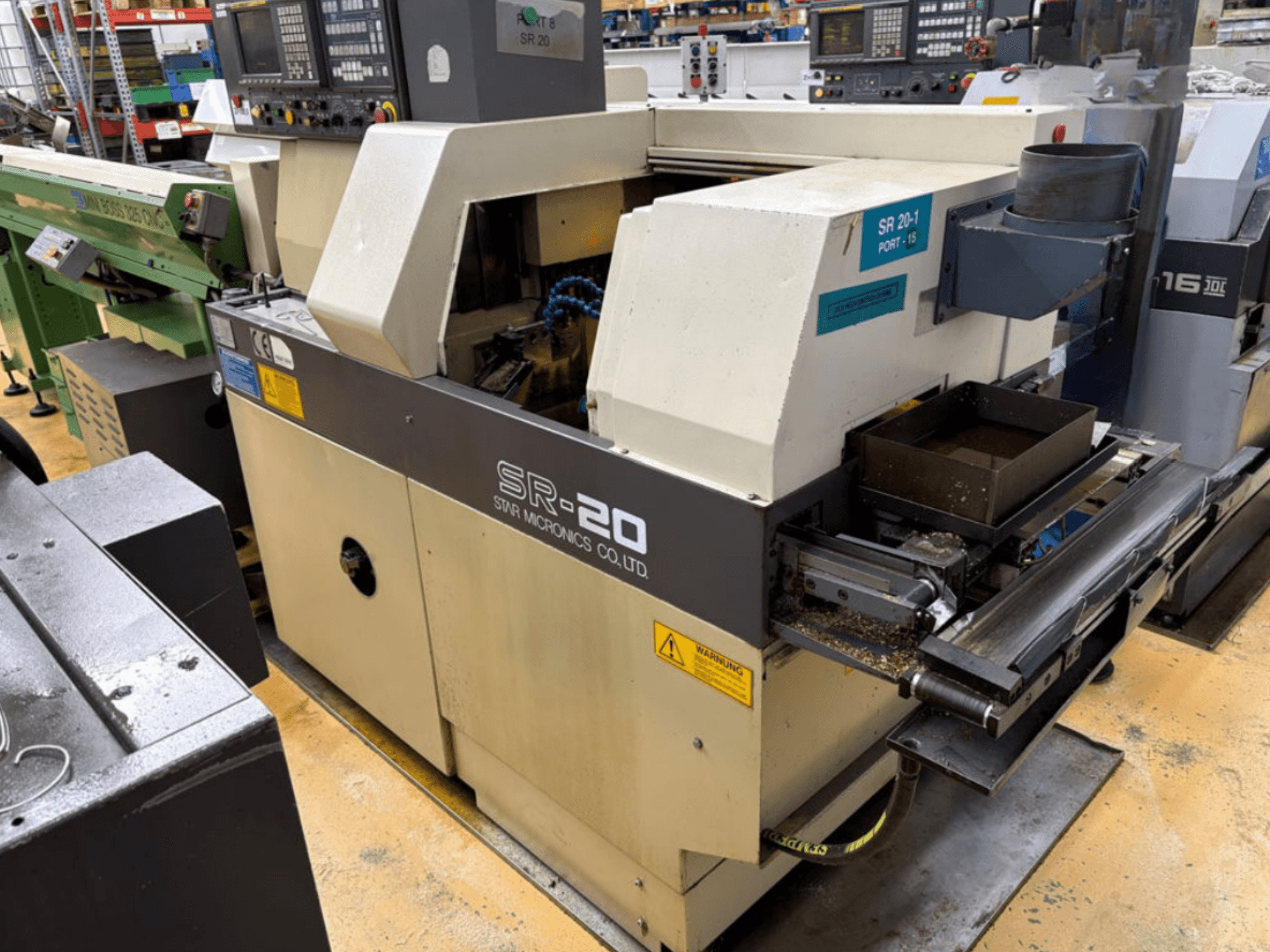 STAR MICRONICS SR20 Drehmaschine nach Schweizer Bauart in Seitenansicht, mit Bedienfeld und Werkzeugbereich mit Spänen.