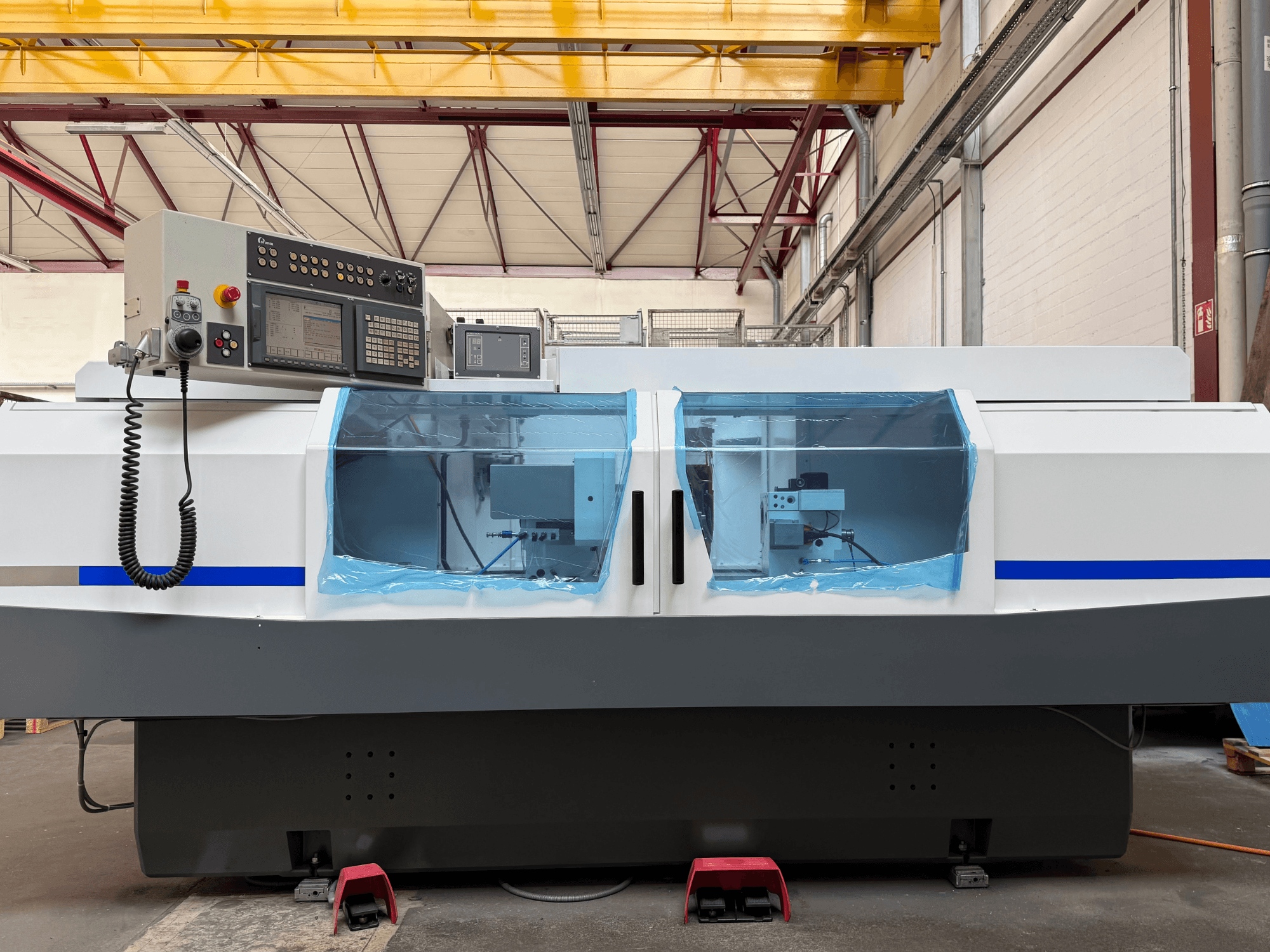 Zylinderschleifmaschine STUDER S33 CNC in Seitenansicht, mit Bedienfeld und transparenten Schutzabdeckungen.