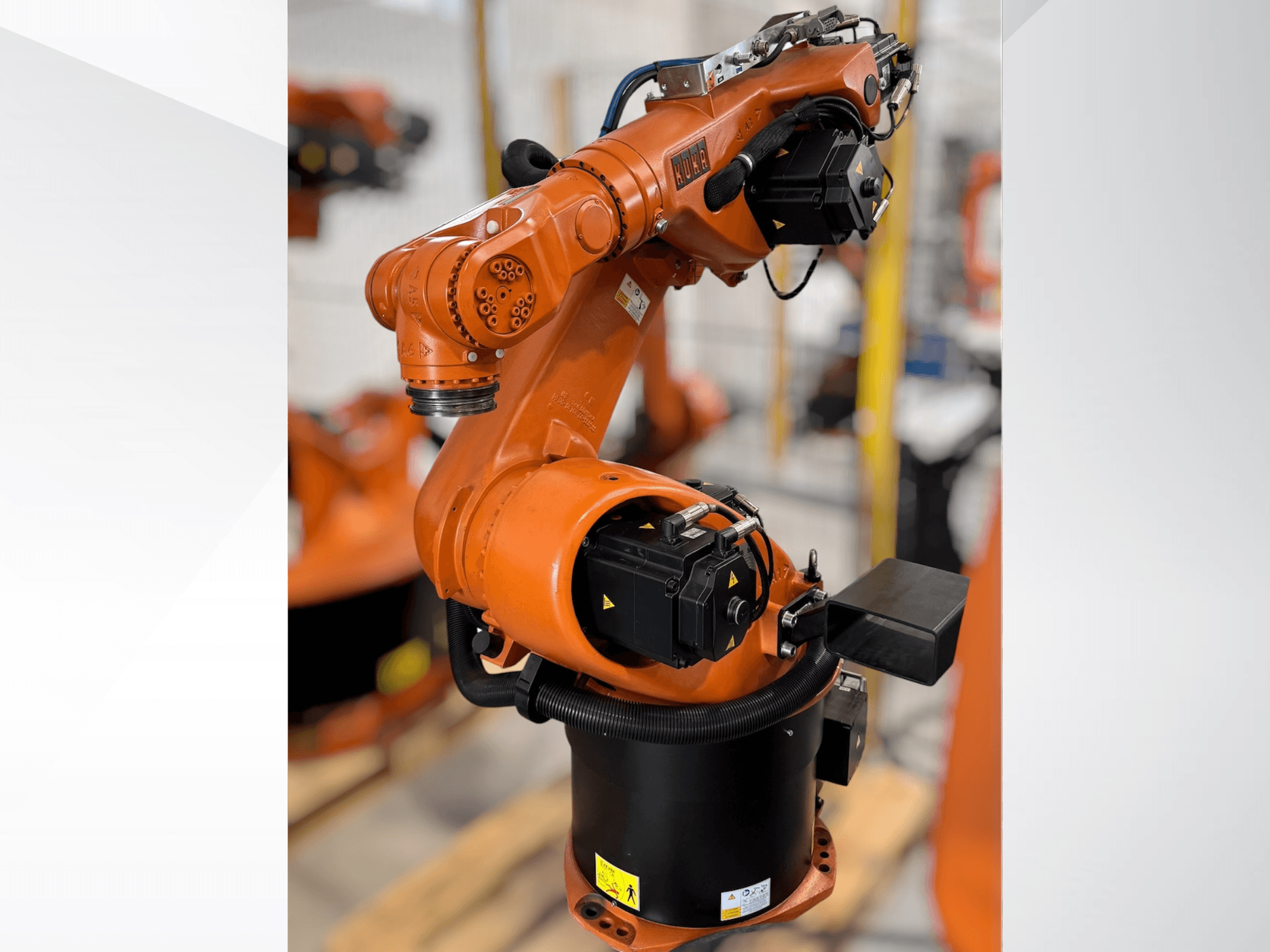 KUKA Roboterarm KR 60-3 in orange; Seitenansicht mit Basis, Gelenken und Steuerungsmodulen für Automatisierungsaufgaben.