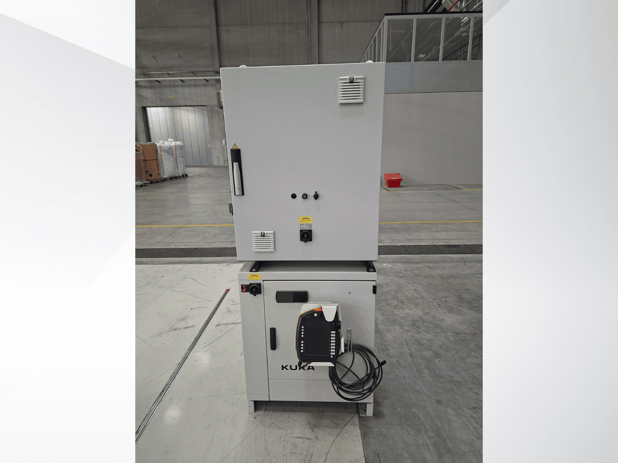 KUKA KR 90 R2700 PRO C4 FLR Roboterarm-Steuerung, Vorderansicht mit Bedienfeld und Sicherheitsaufklebern in einem geräumigen Lager.