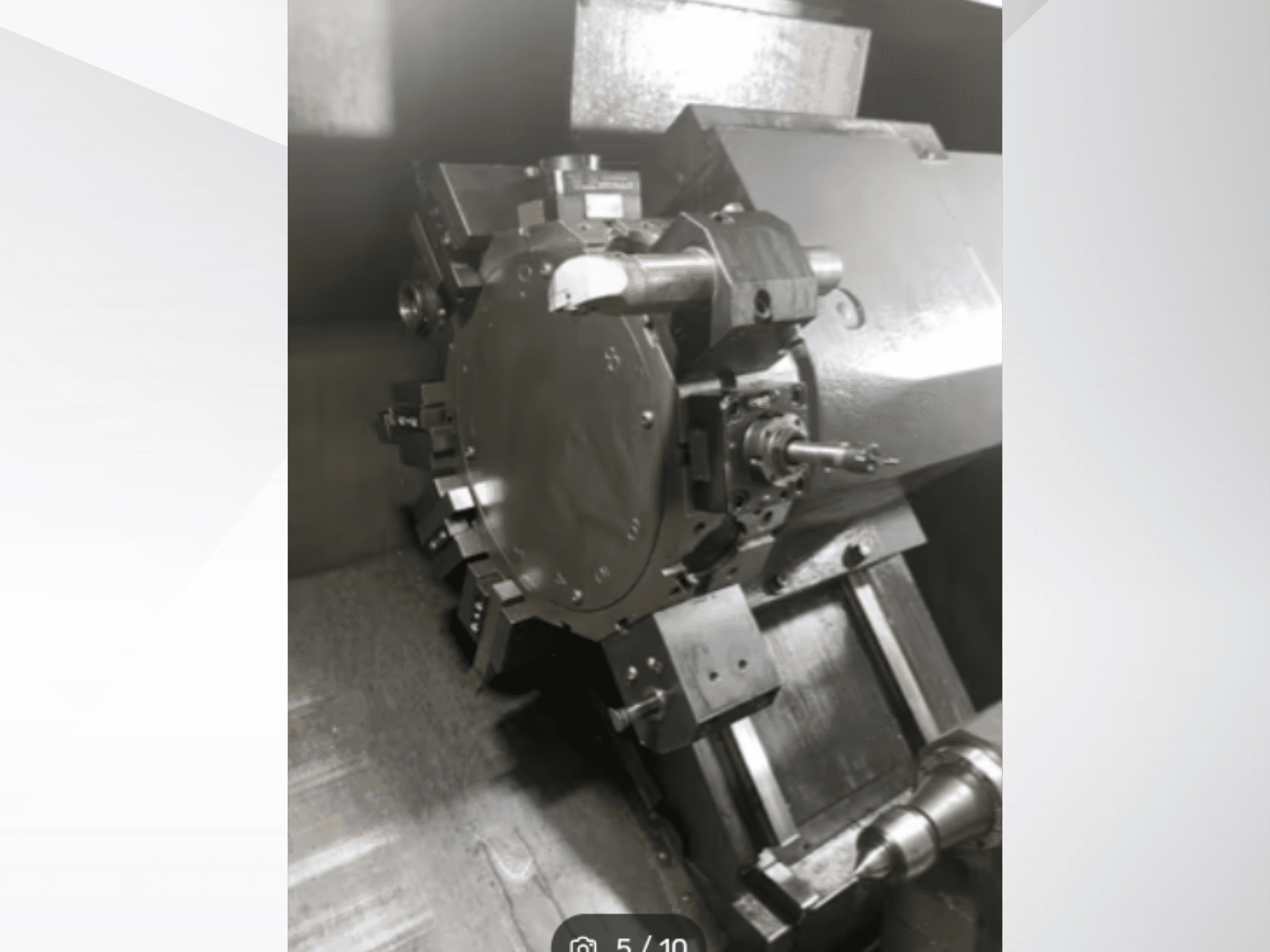 Nahaufnahme eines Präzisionsmaschinenteils mit Zahnrädern und Metallkomponenten, aus einer schrägen Perspektive betrachtet. Keine Marke sichtbar.