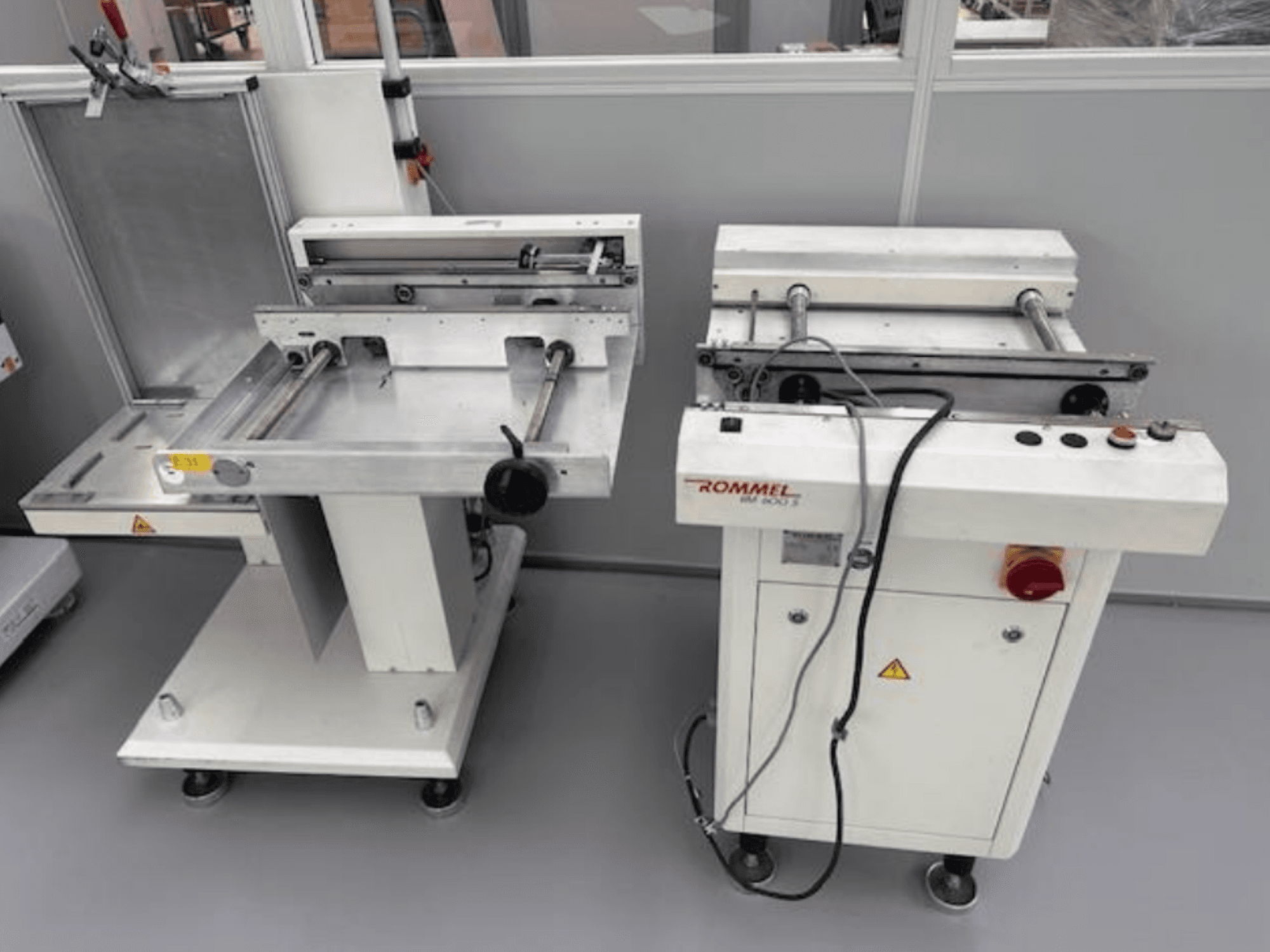 Rommel HM 5033 Etikettiermaschine, Vorderansicht; mit Bedienfeld, Rollen und Oberflächen aus Edelstahl.