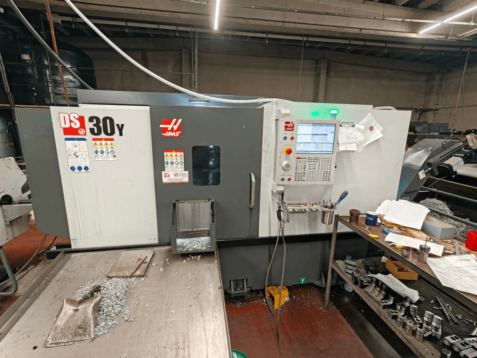Horizontaldrehmaschine HAAS DS30Y in einer Werkstatt, Vorderansicht mit Bedienfeld und Metallspänen auf der Oberfläche.