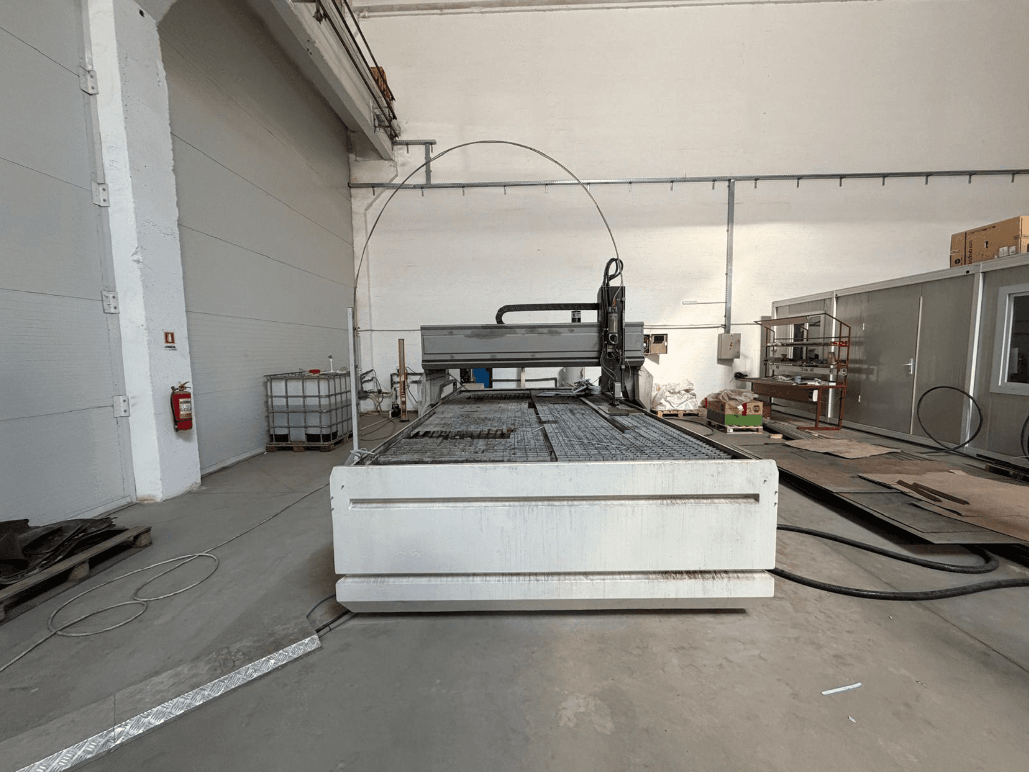 CMS SMARTLINE 2040 Wasserstrahlschneidemaschine, Vorderansicht, die ihre große, ebene Arbeitsfläche und die industrielle Umgebung zeigt.