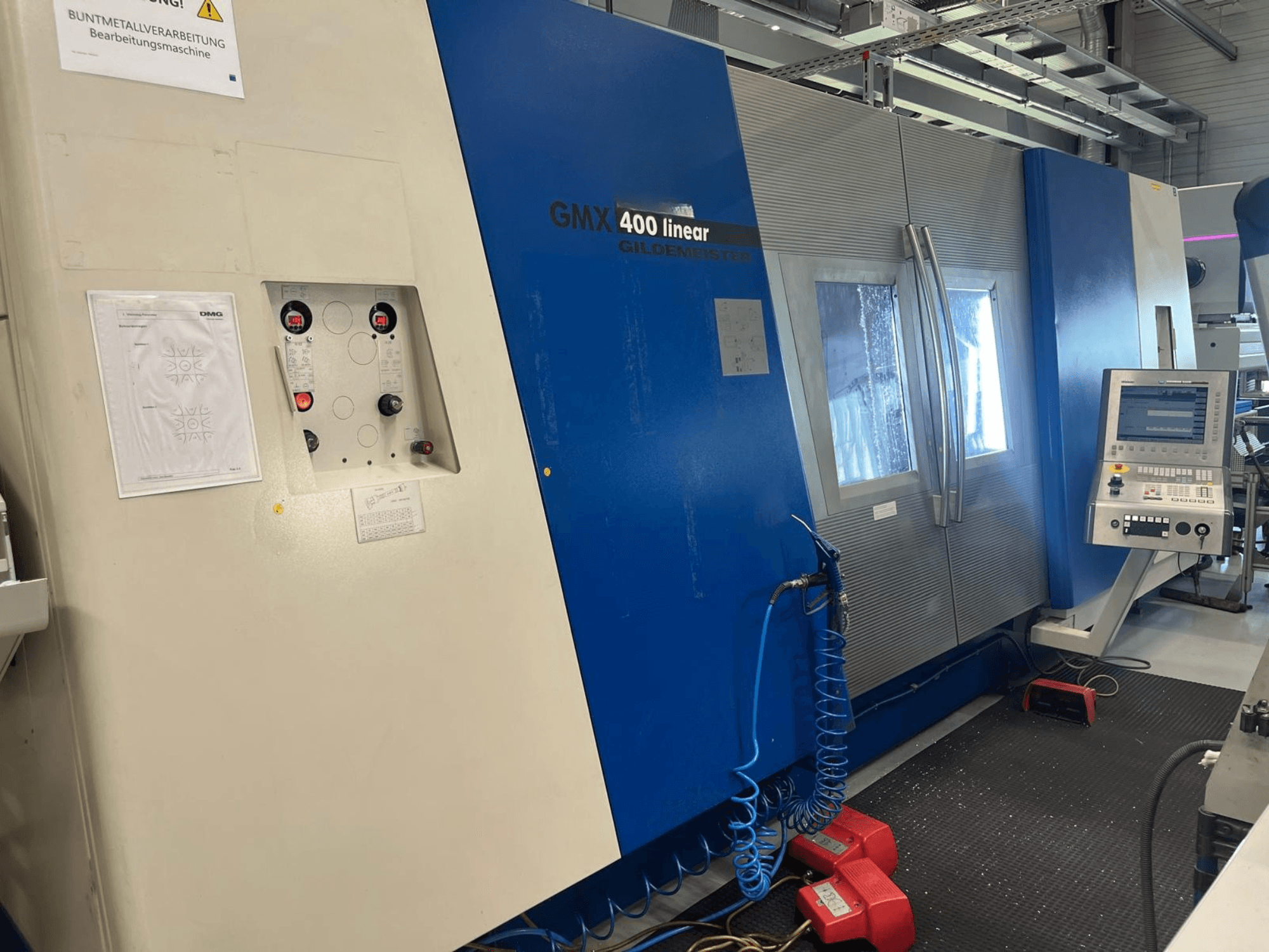 Gildemeister GMX 400 Linear-Dreh-Fräszentrum, Vorderansicht mit Bedienfeld, Kühlmittelsystem und Bedientasten.