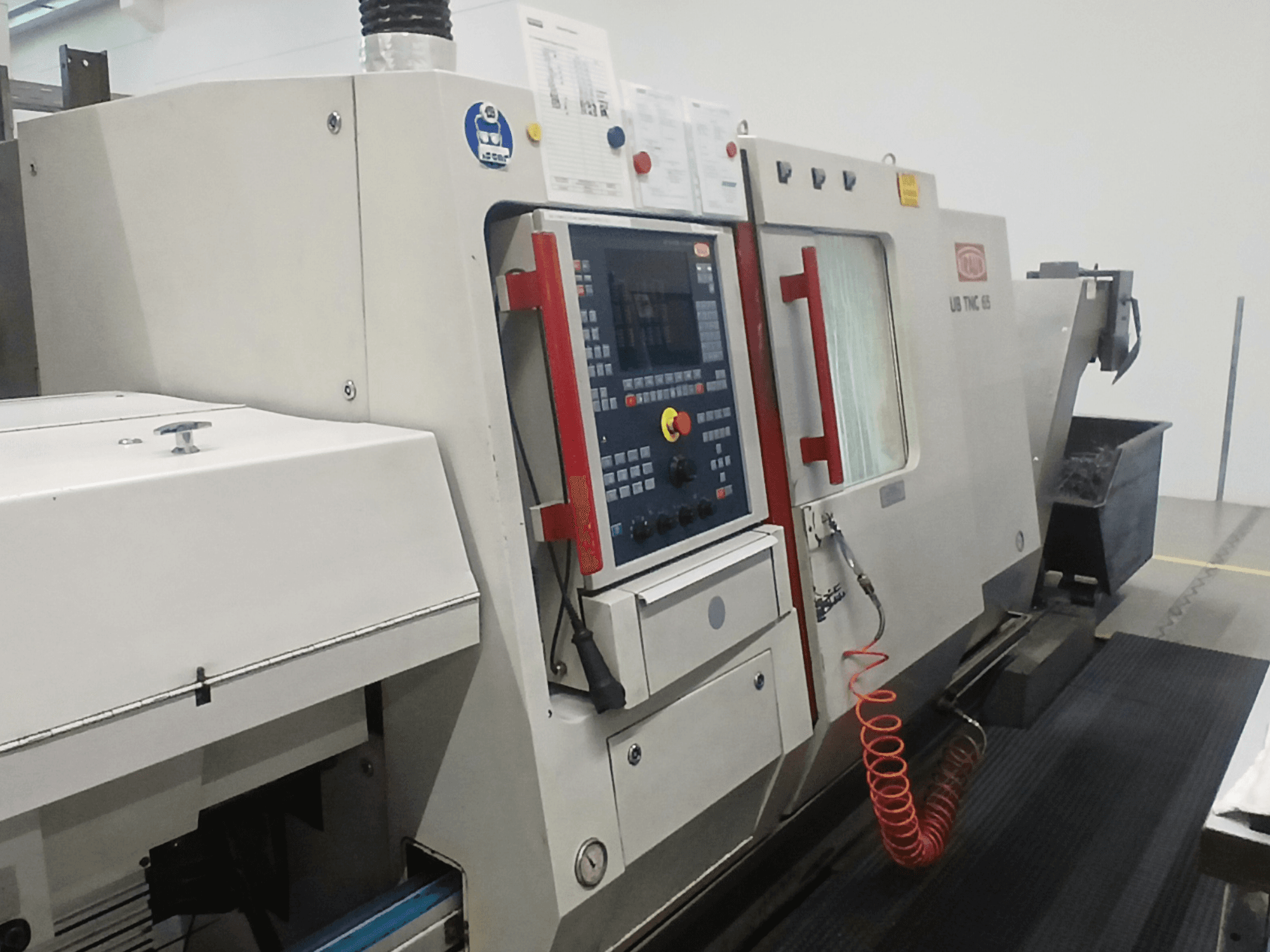 Horizontal-Drehmaschine TRAUB TNC65 DG, Vorderansicht mit Bedienfeld und Werkzeugen, ideal für die Präzisionsbearbeitung.