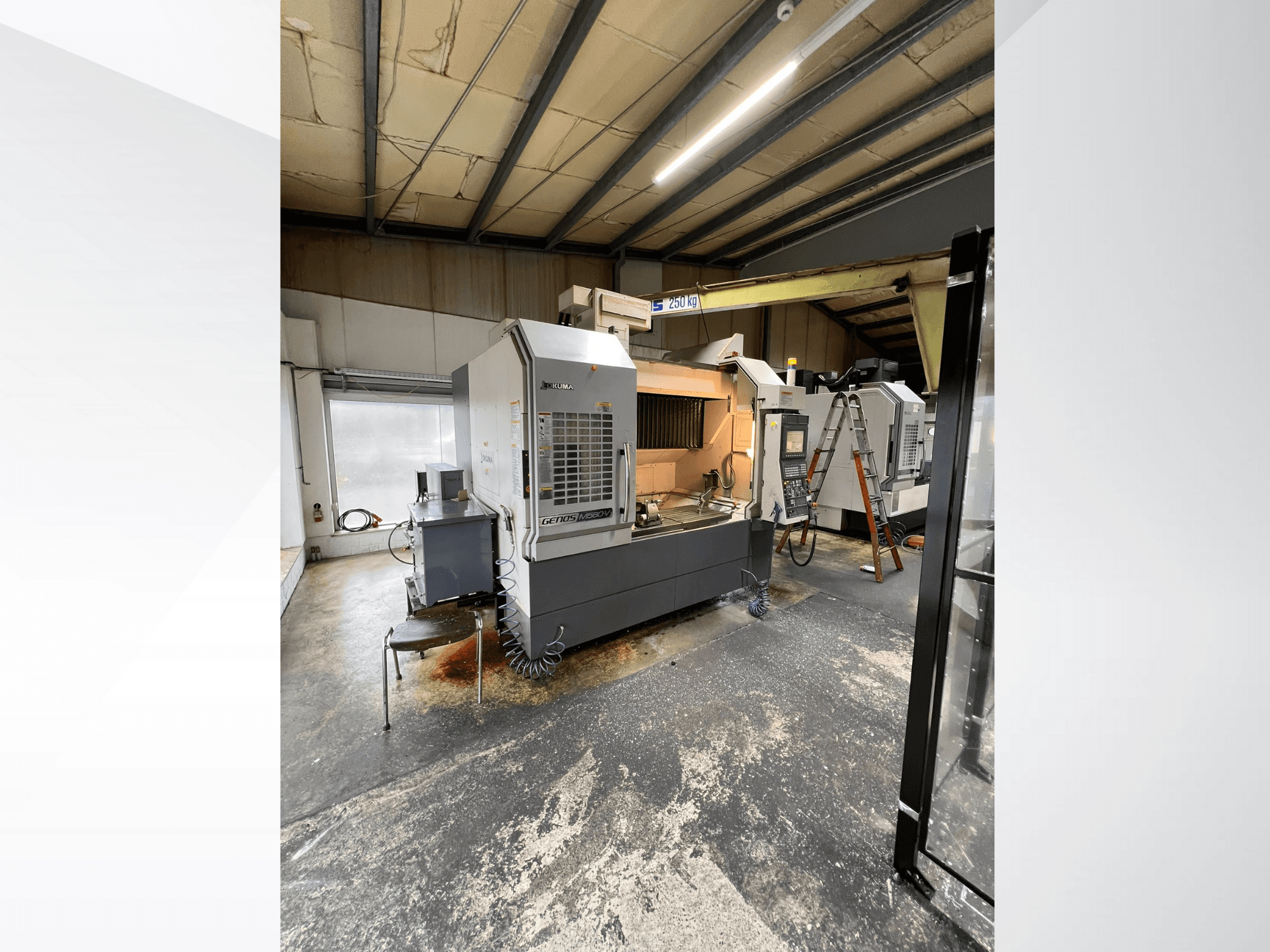 GRETOS 750 CNC-Maschine in einer Werkstatt, Vorderansicht, zeigt Bedienfeld und Arbeitsbereich mit Werkzeugen, im Hintergrund ist eine Leiter zu sehen.